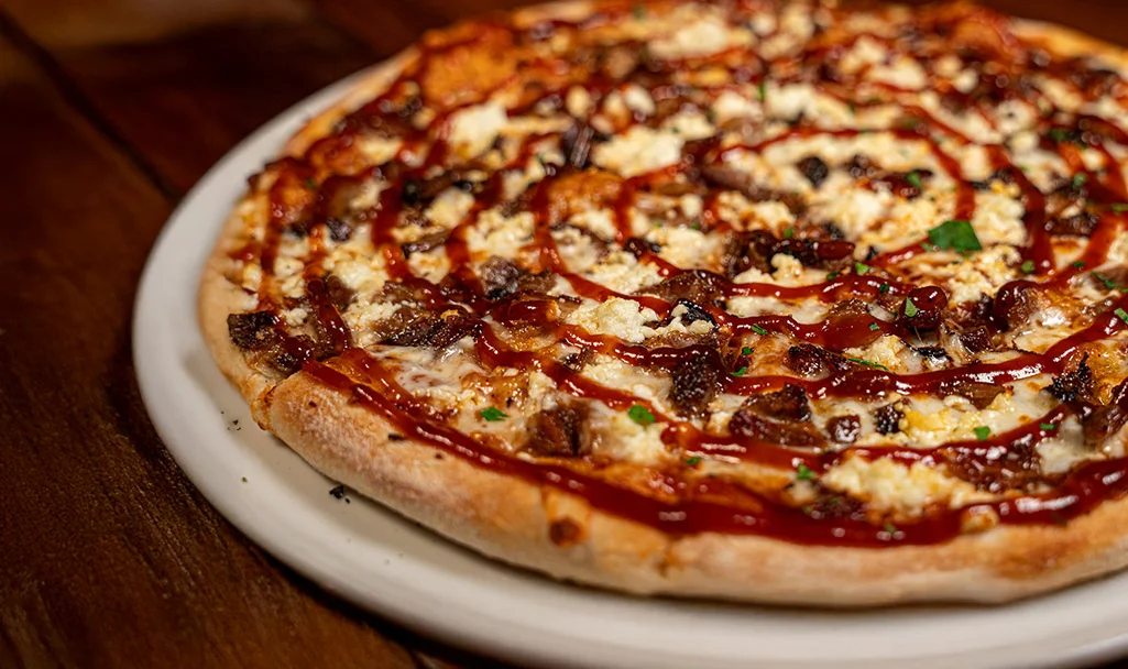Brick-oven pizzas and flatbreads baking in the artisan oven at Noosh Nosh on Brownsboro Road in Louisville’s Clifton neighborhood, topped with fresh ingredients and bold flavors.