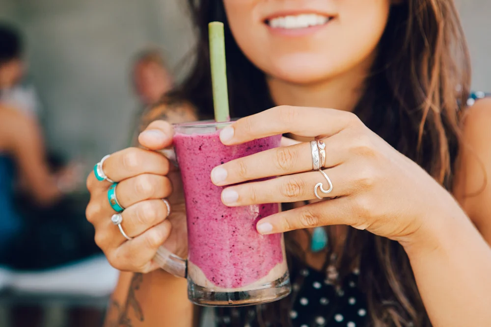 Refreshing berry smoothie in a glass mug with a straw