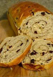 Swirled cinnamon raisin bread loaf on a wooden cutting board