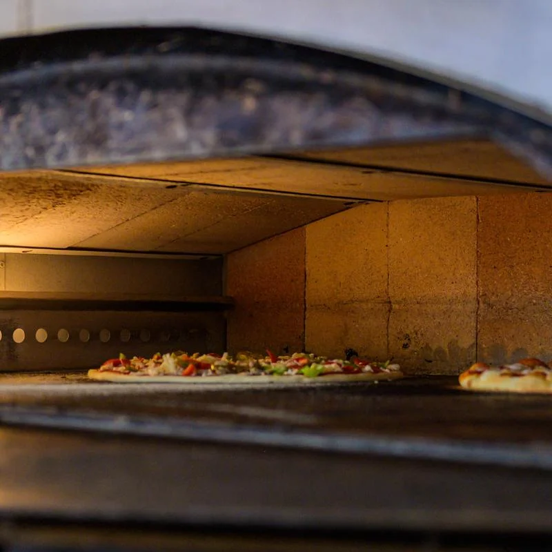 Pizzas baking in a traditional wood-fired oven