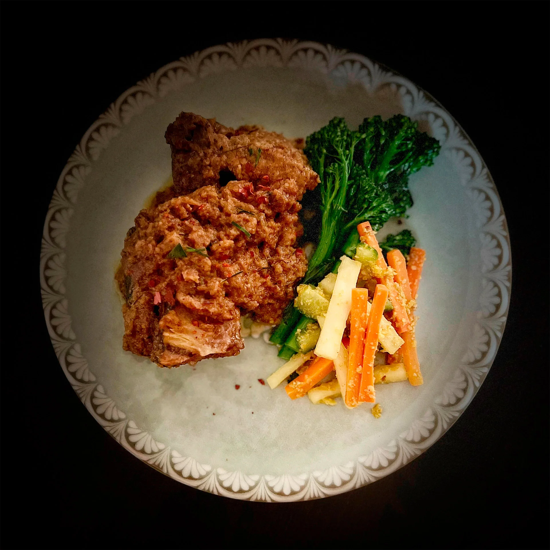 Savory Indonesian rendang with vibrant vegetable medley on a decorative plate