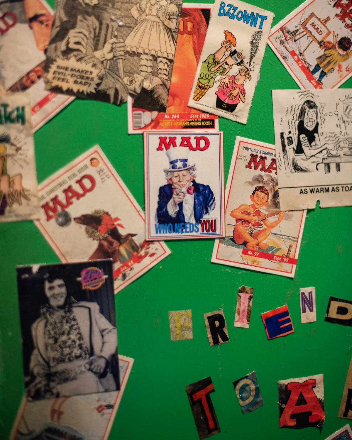 Colorful collage of vintage magazine covers and photos on a green wall