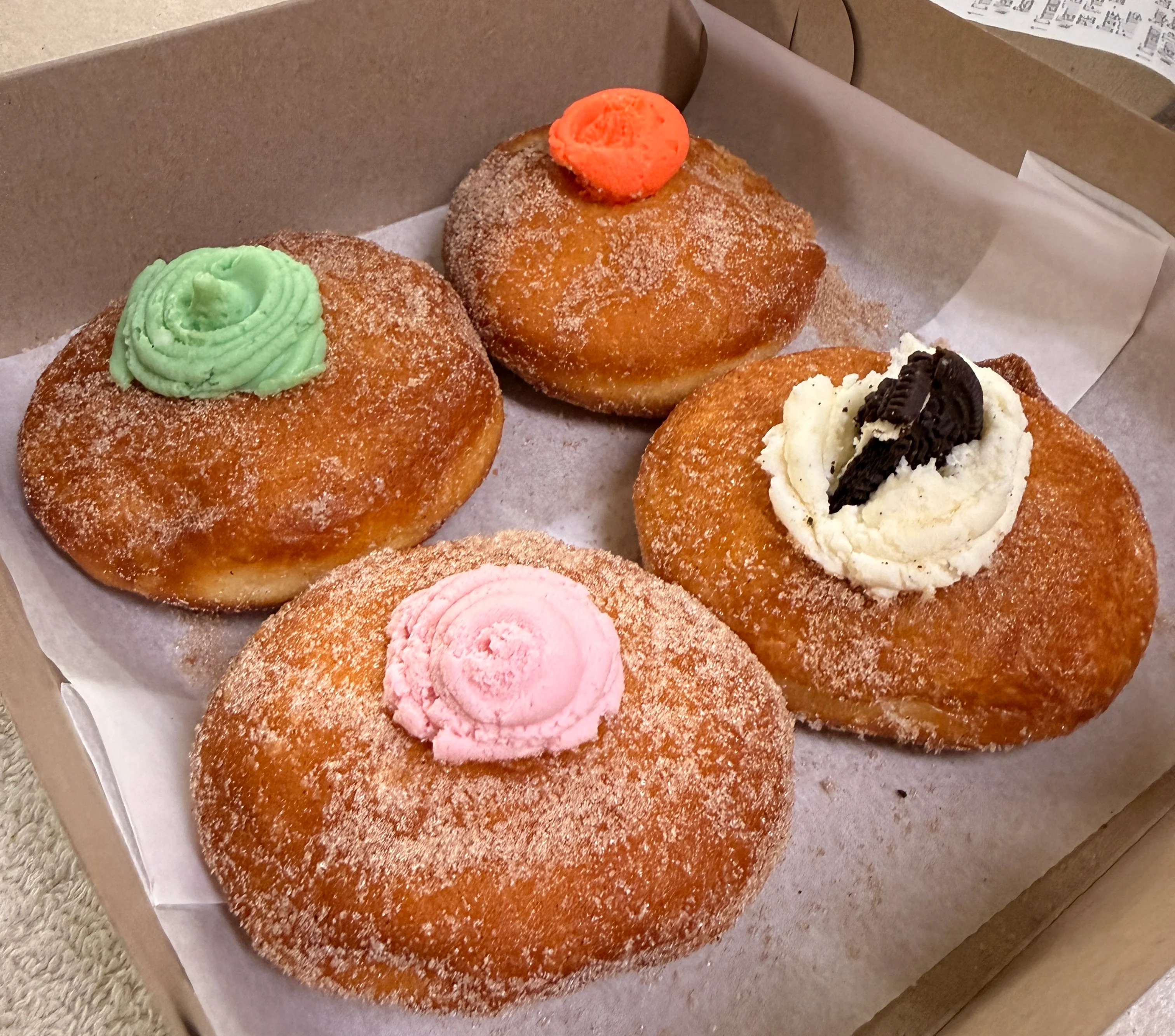 Colorful frosted donuts in a box, a sweet treat from American bakeries