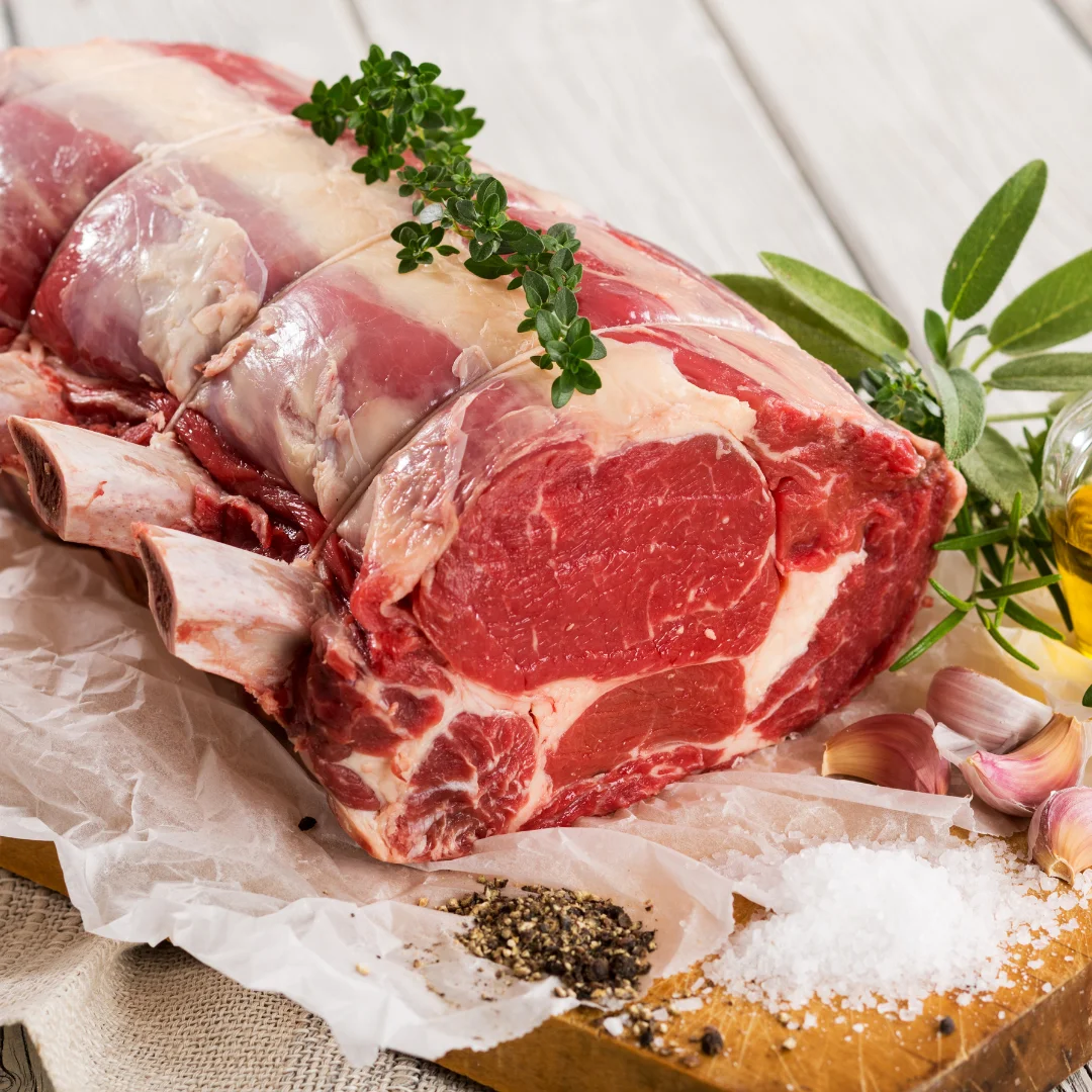 A beautifully cooked rib roast on a wooden cutting board.