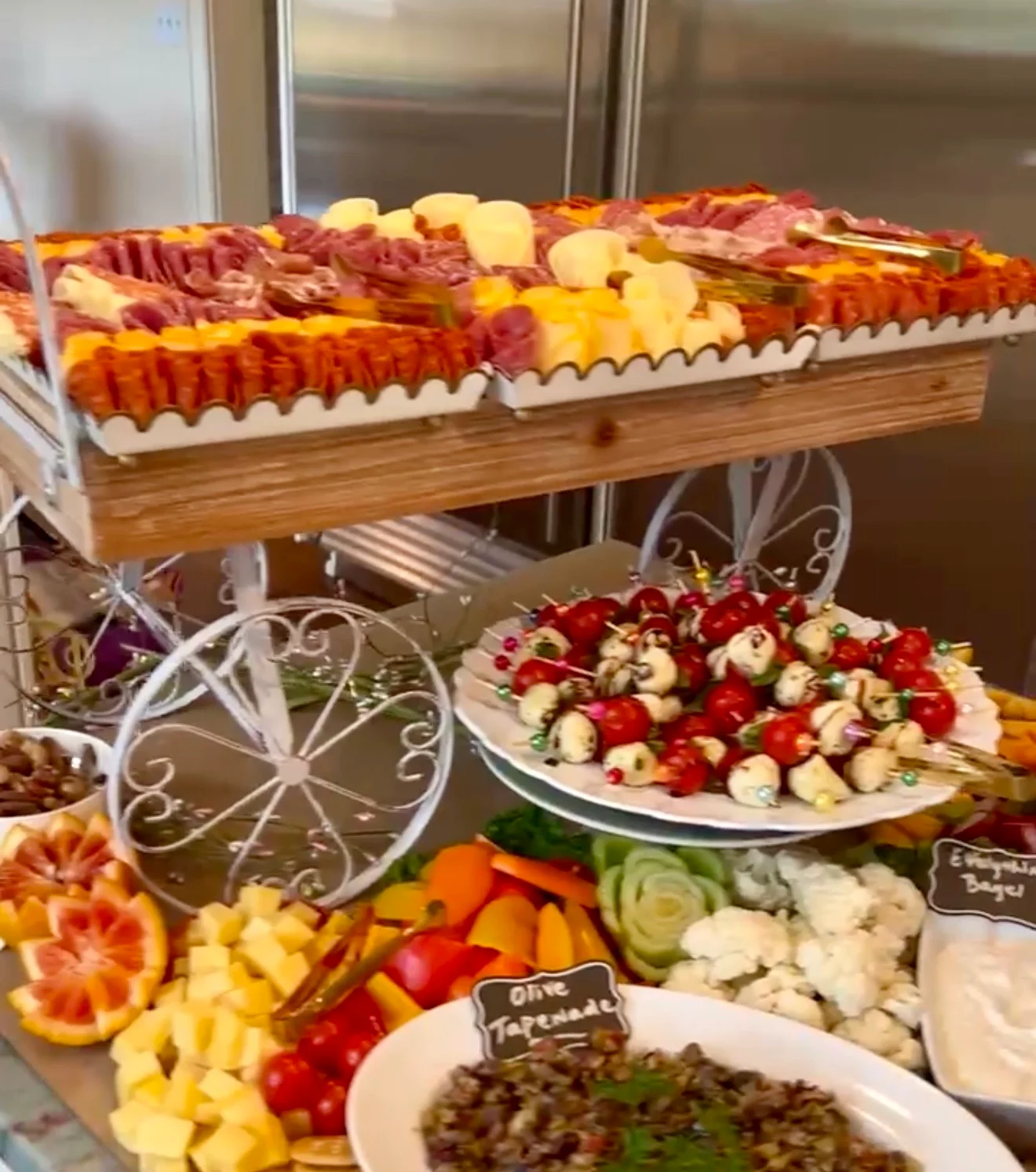 A beautifully arranged charcuterie board with meats, cheeses, and vegetables.