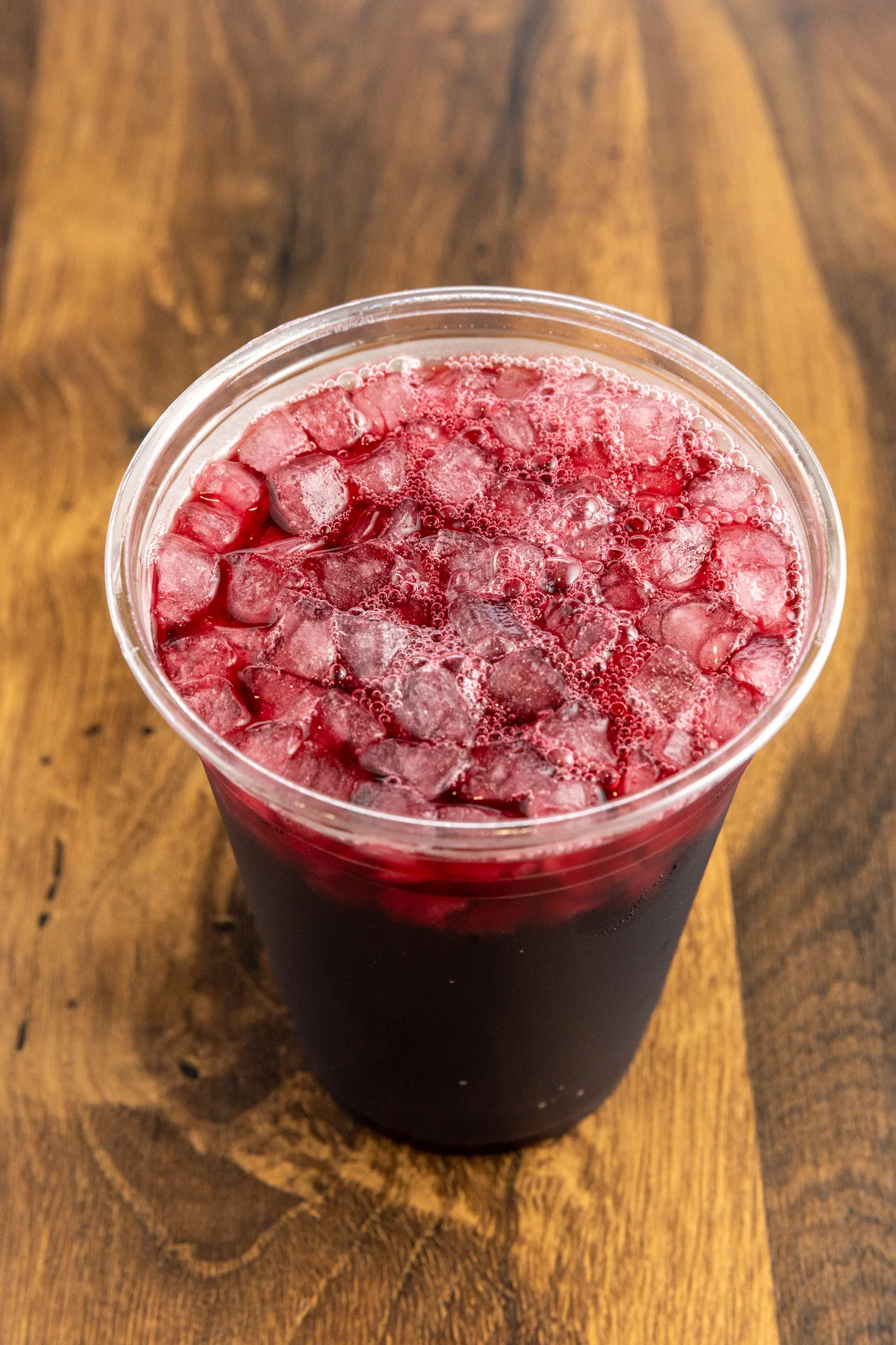 Refreshing hibiscus iced tea in a clear cup with ice