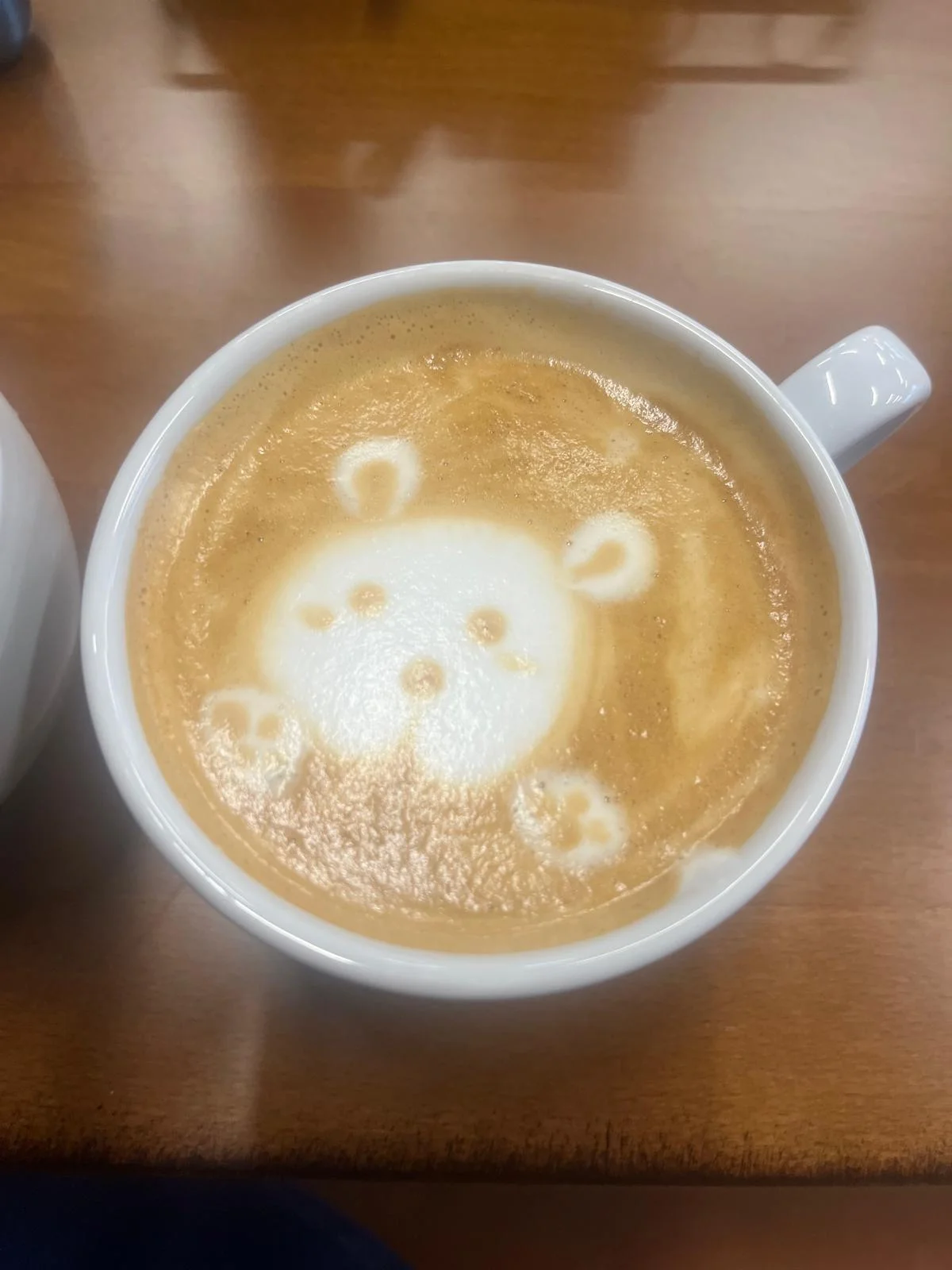 Latte art featuring a cute bear design in a coffee cup.