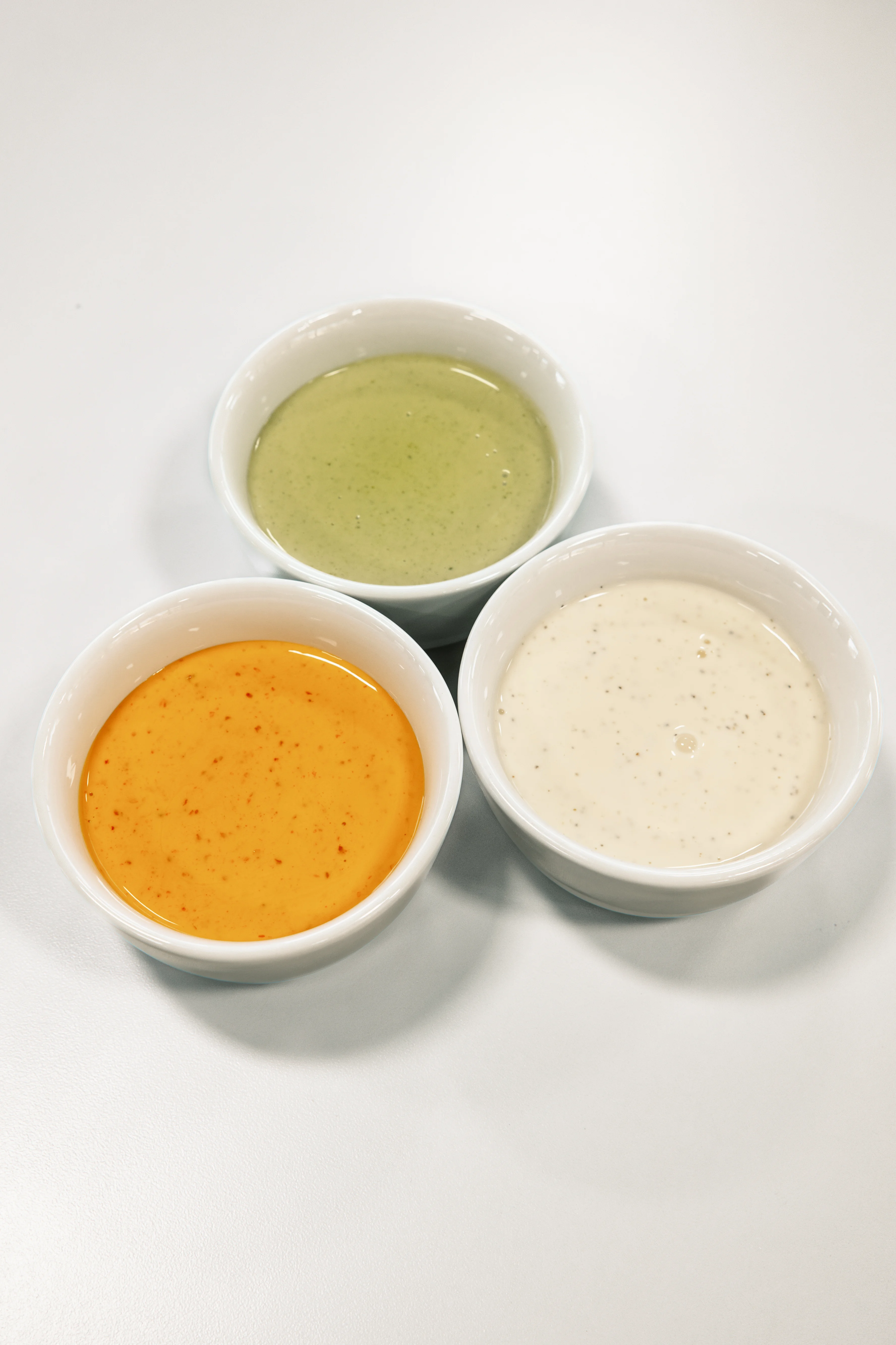 Three vibrant dipping sauces in small bowls
