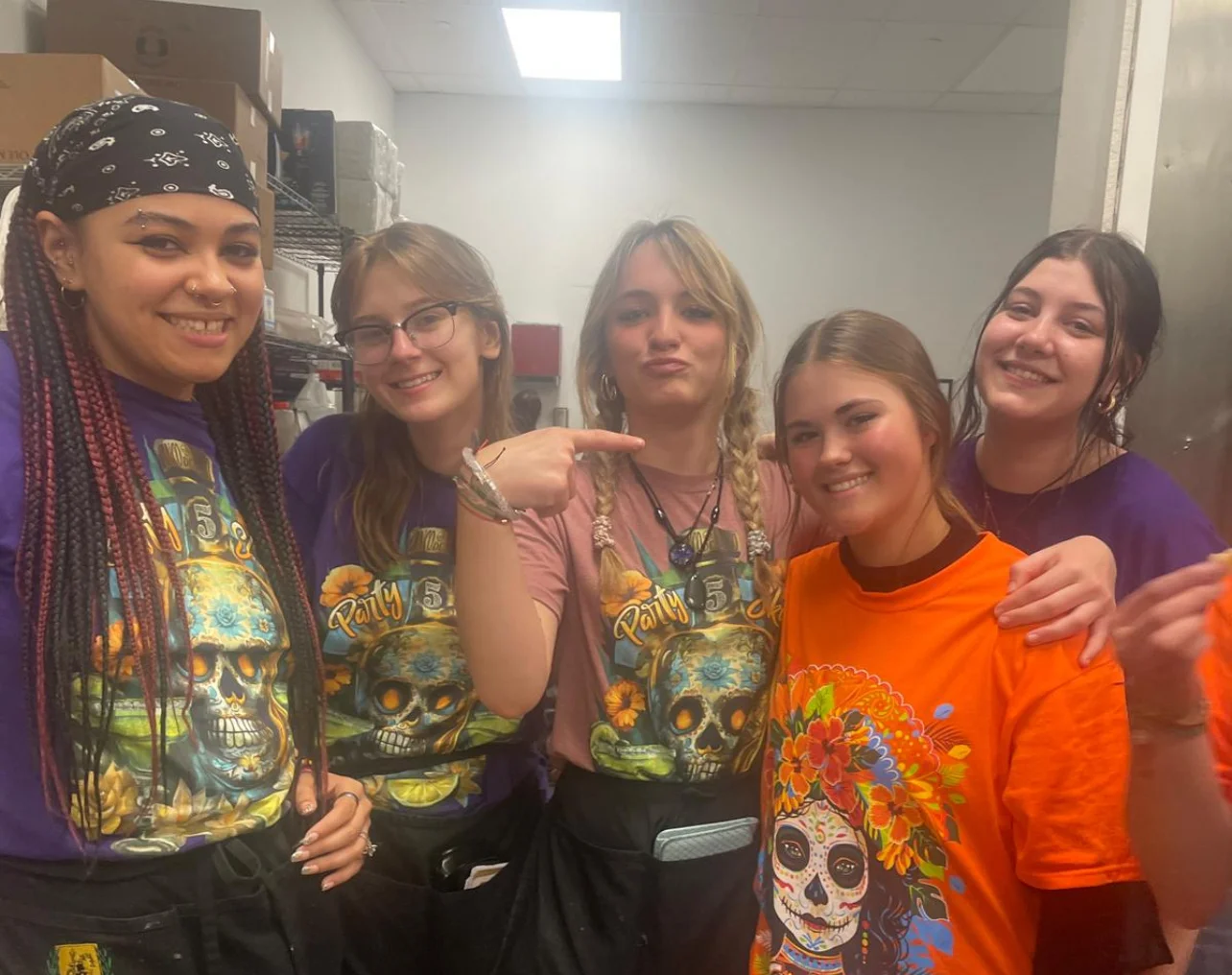 Group of restaurant staff posing in colorful shirts