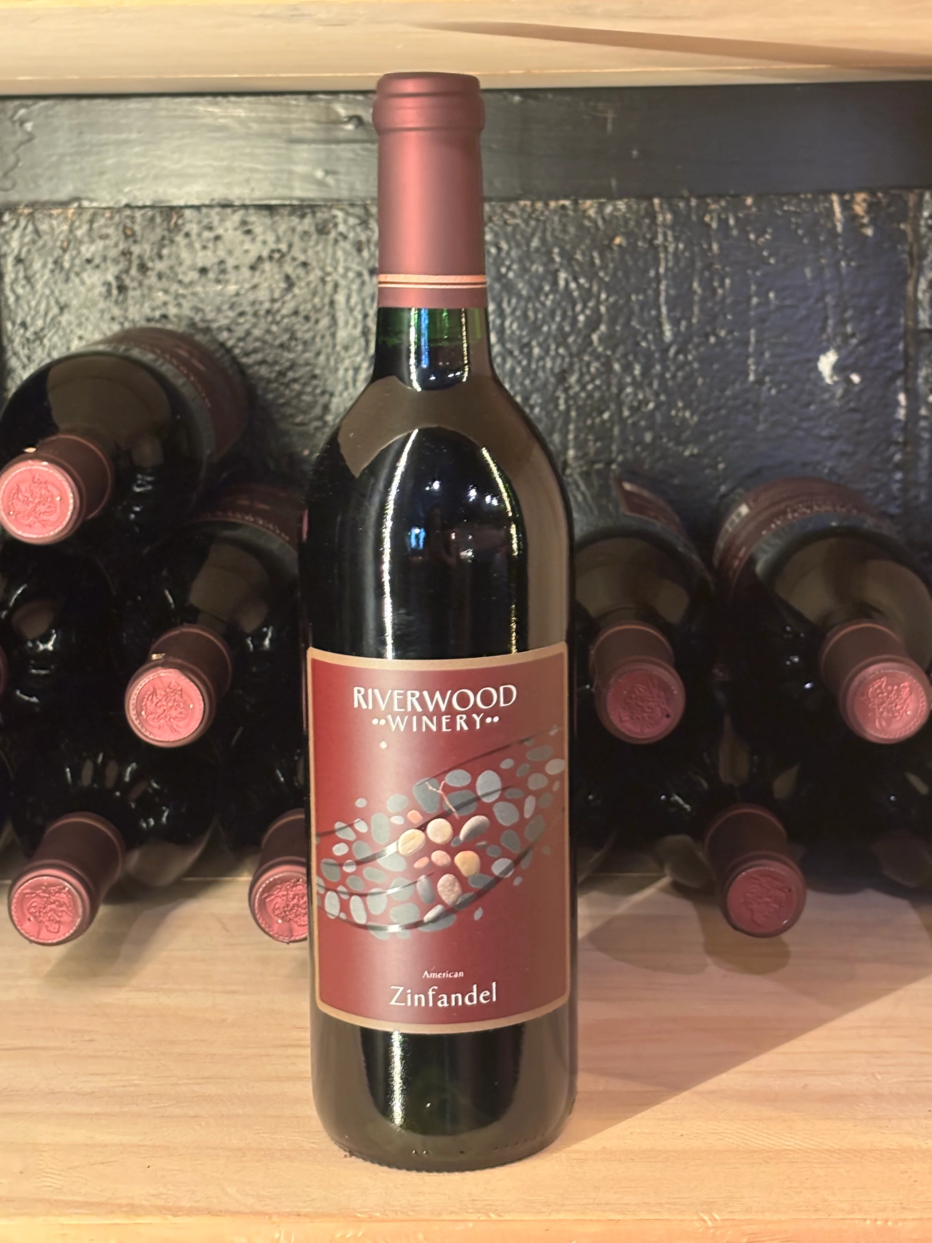 Bottle of Riverwood Winery Zinfandel on a wooden shelf