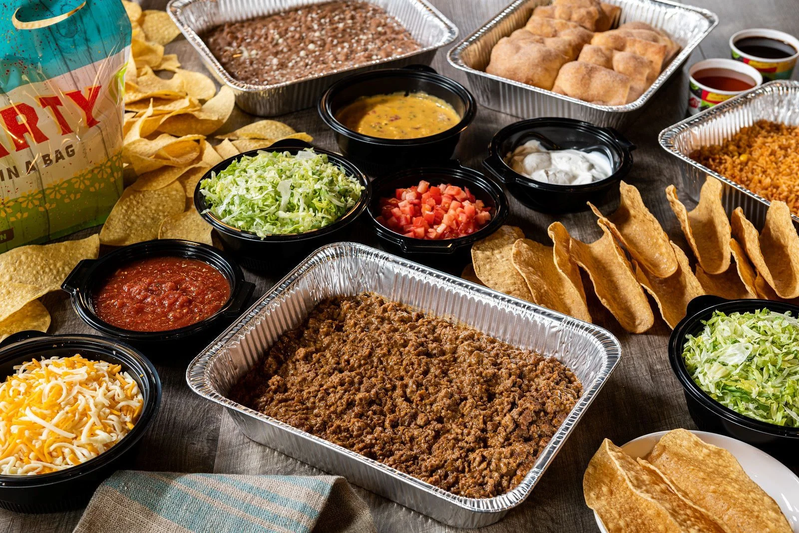 Mexican taco bar setup with seasoned beef and fresh toppings