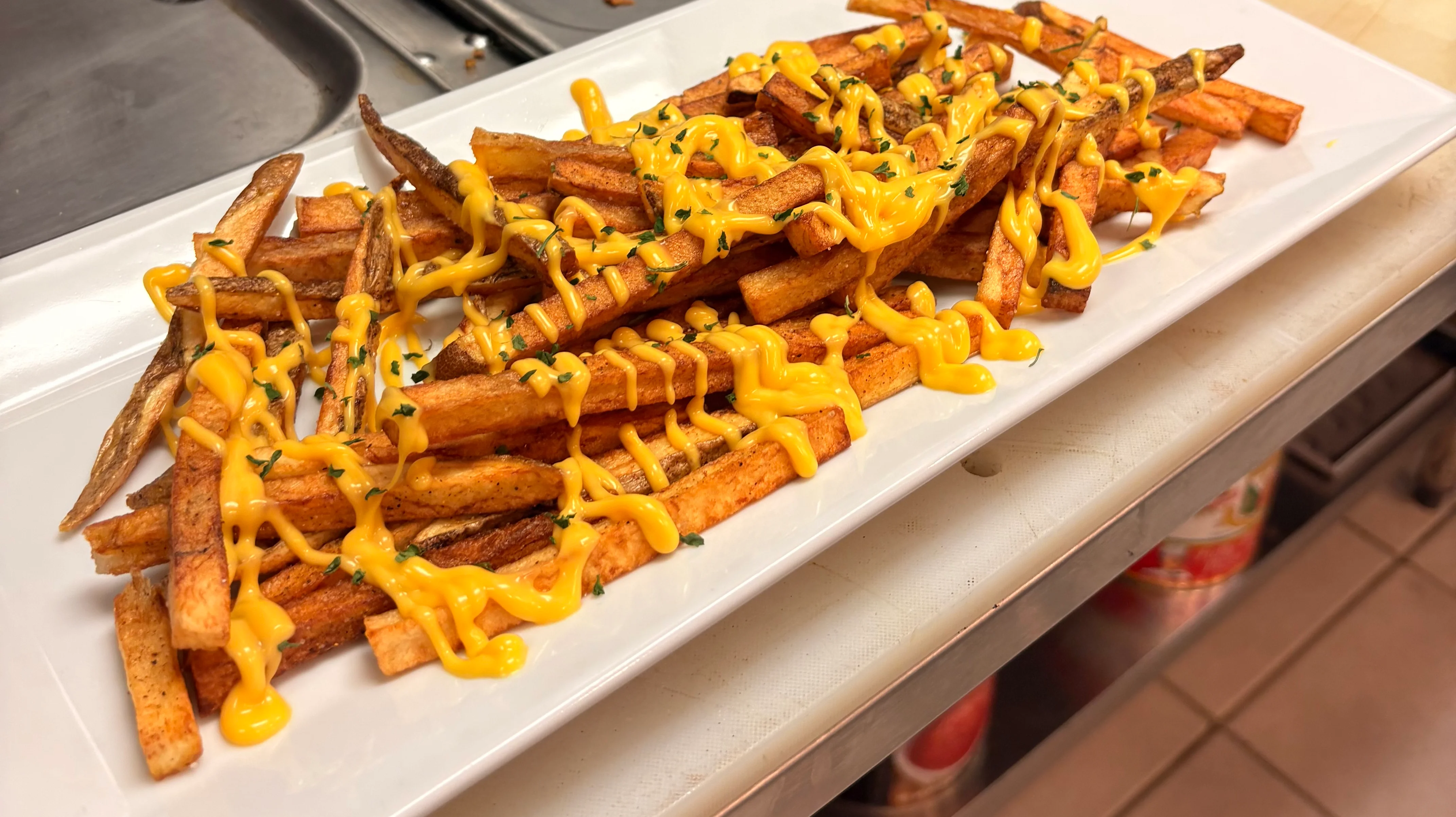 Loaded sweet potato fries drizzled with cheese sauce
