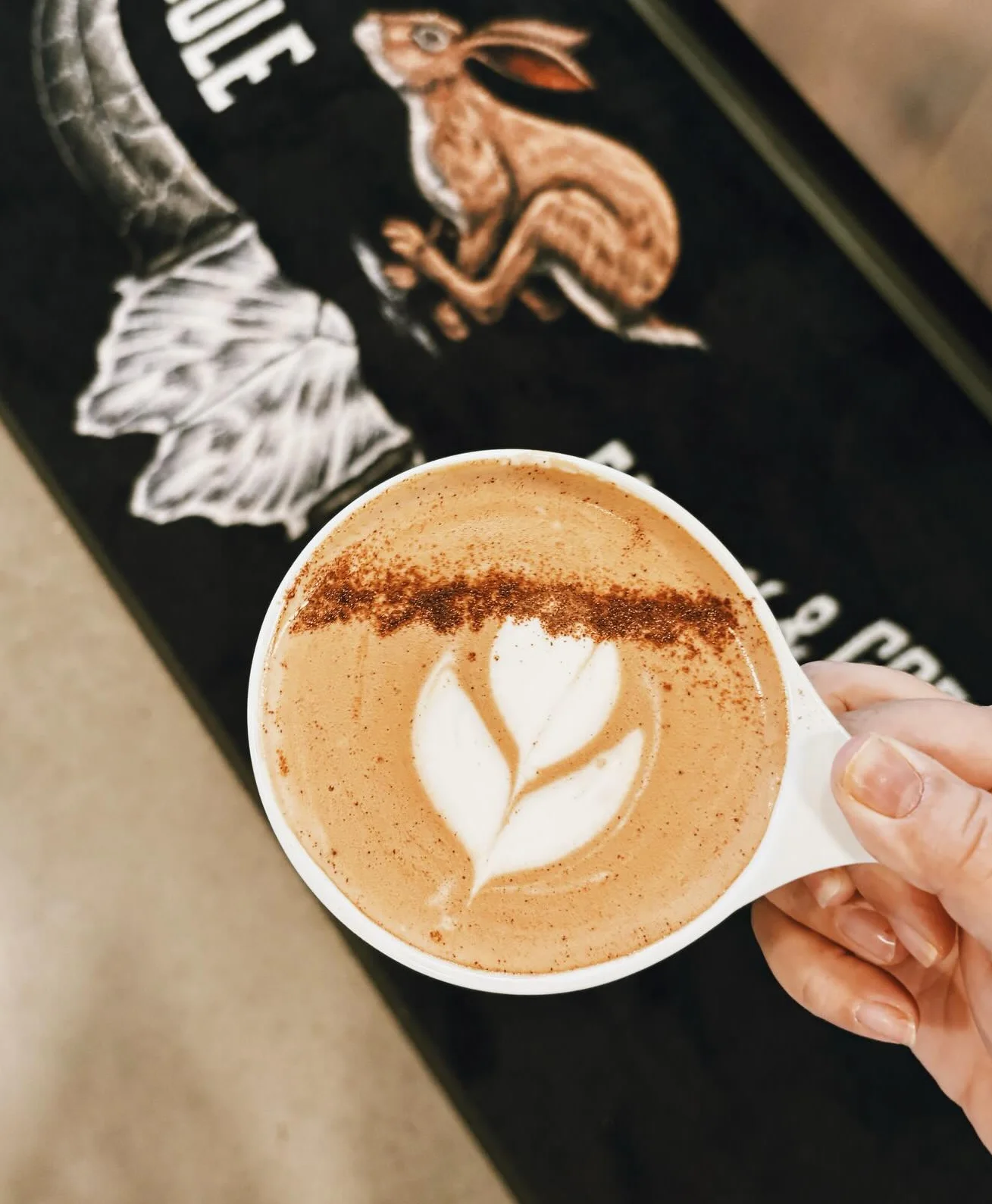 Artisan latte with leaf design on a cafe countertop