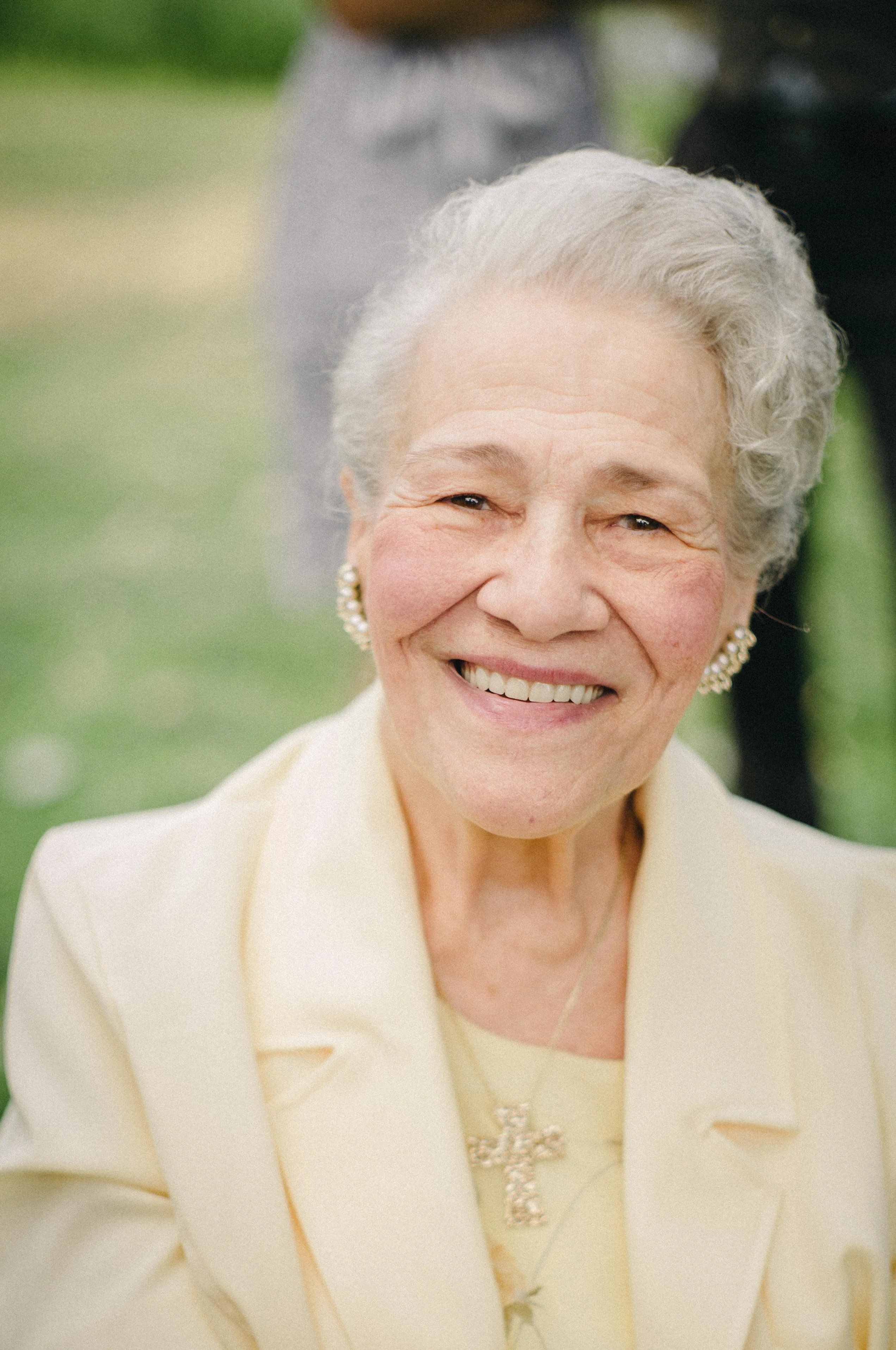 Smiling elderly woman in a light yellow outfit