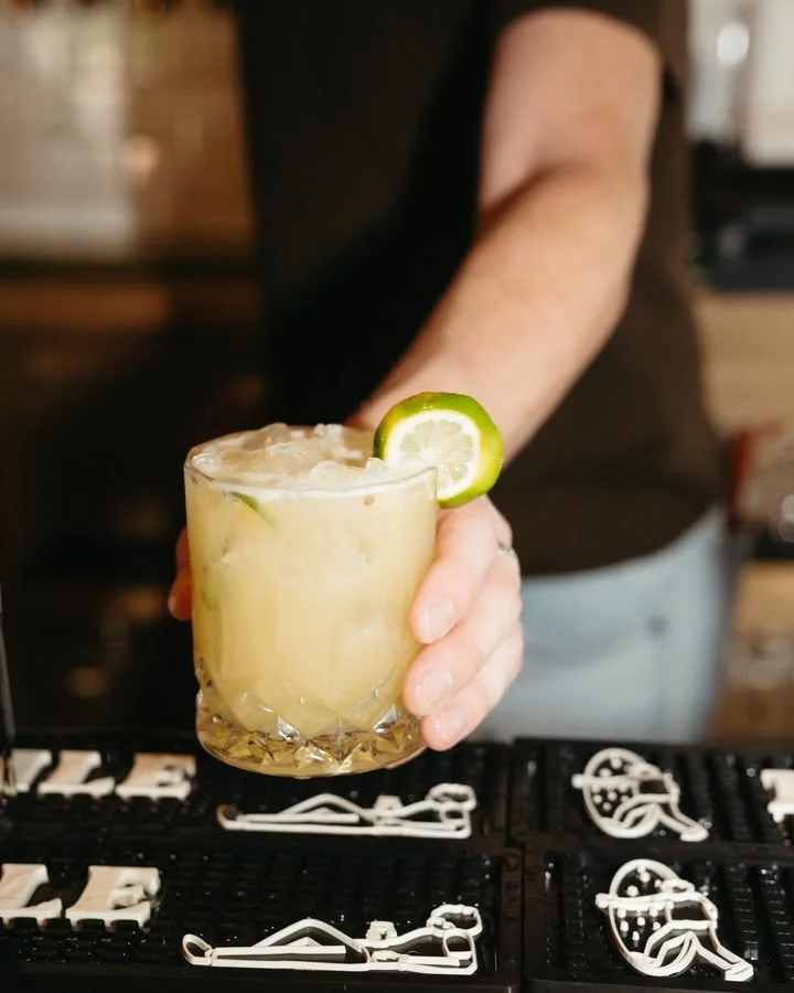 Refreshing cocktail served with lime garnish at a bar