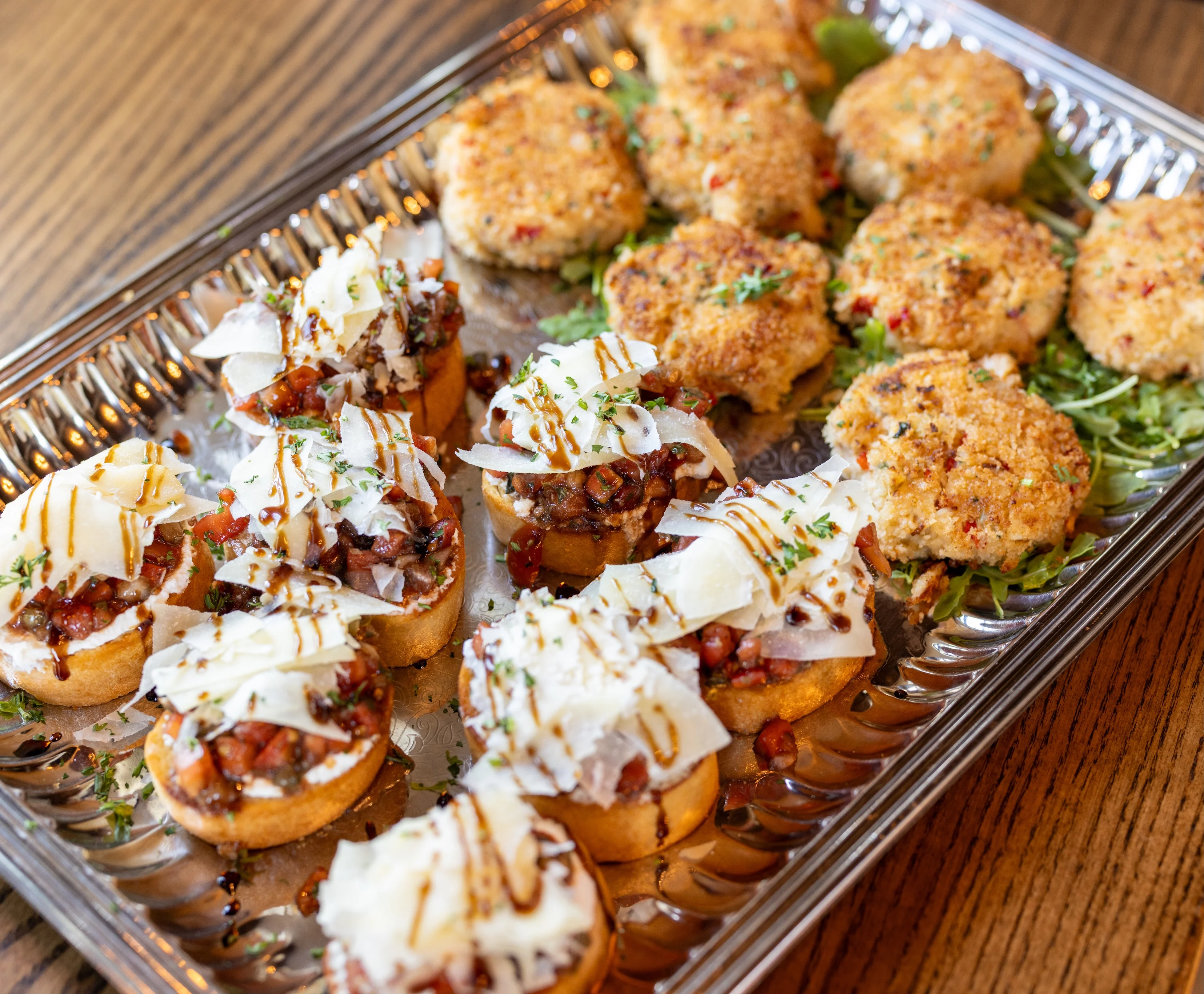 Italian bruschetta and crab cakes on a serving platter