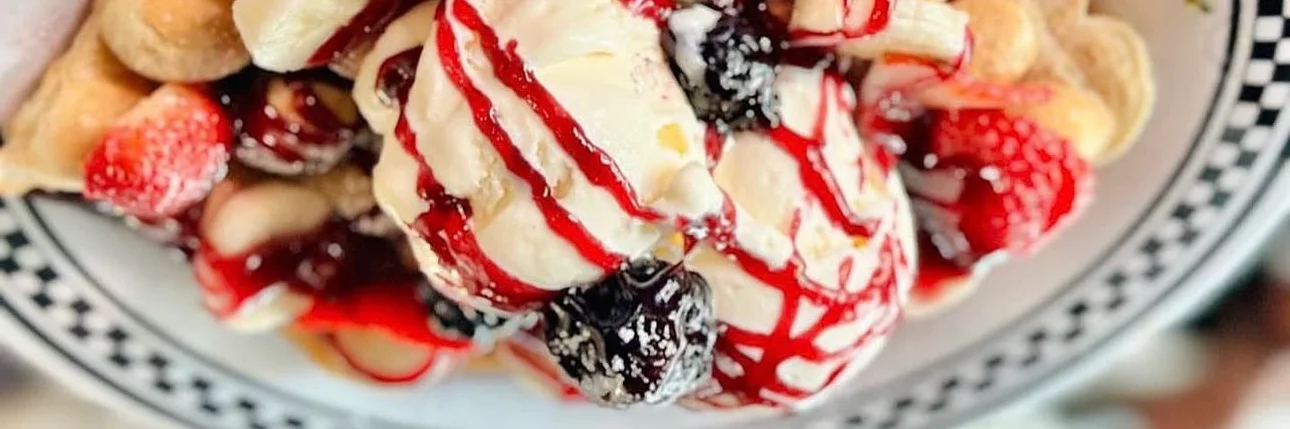Belgian waffle topped with ice cream and fresh berries