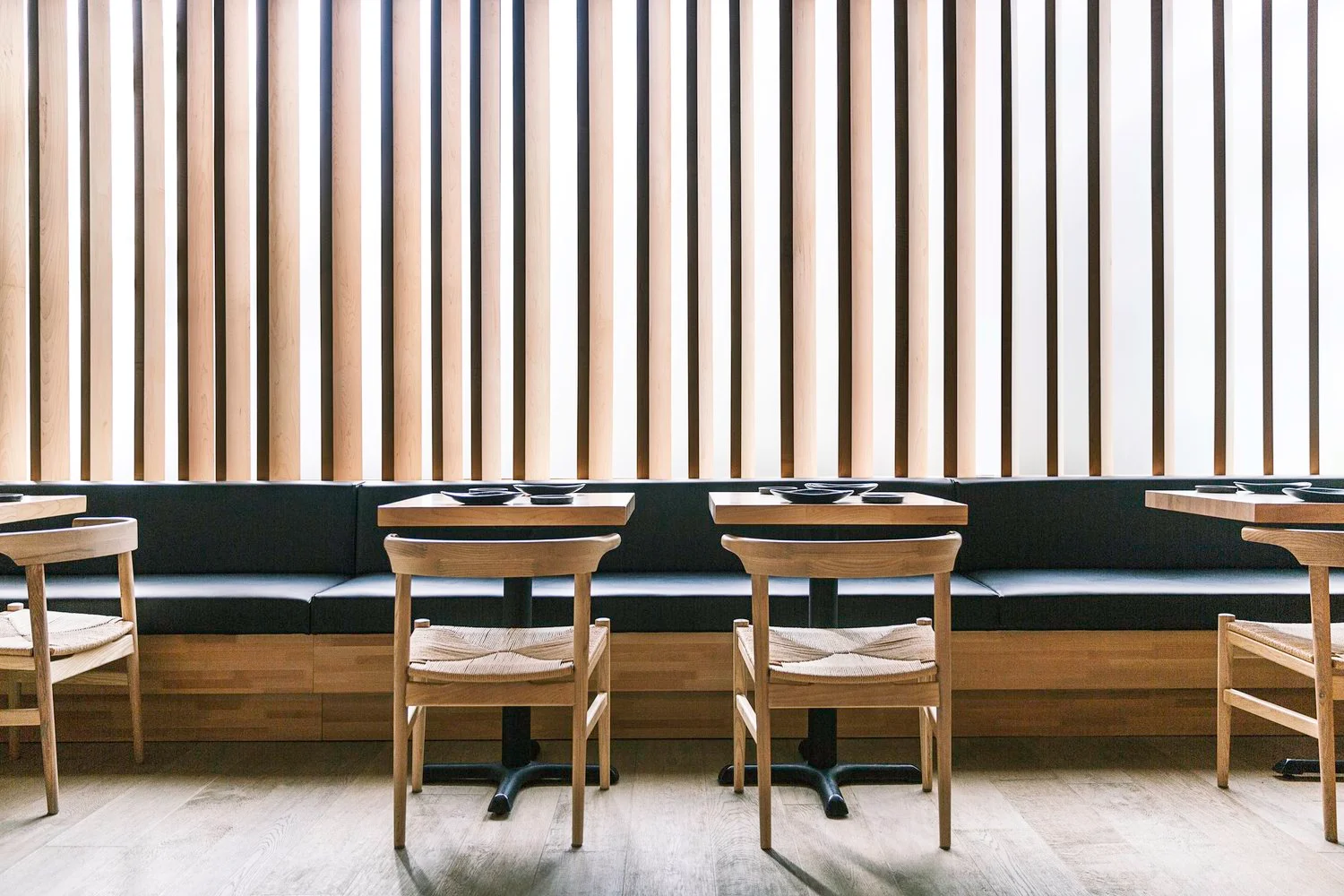 Modern restaurant interior with wooden slats and cozy seating