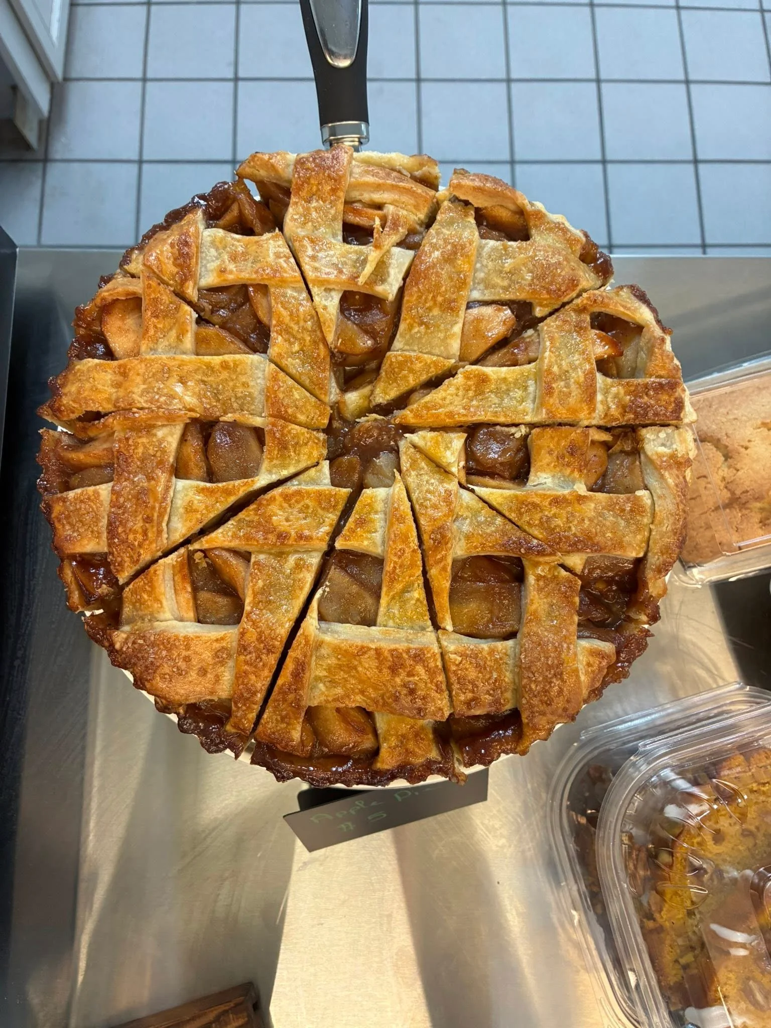 Delicious apple pie with a golden lattice crust on a serving tray.
