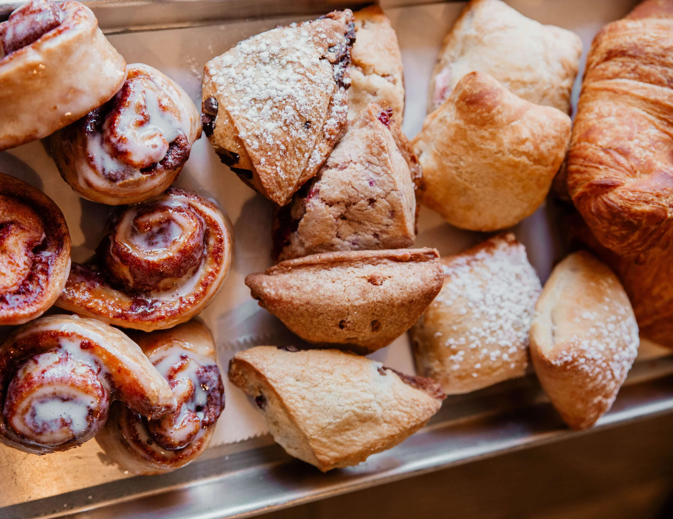 Assorted pastries including cinnamon rolls and scones