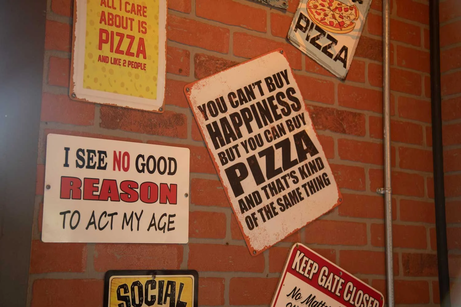 Charming restaurant wall with humorous pizza-themed signage