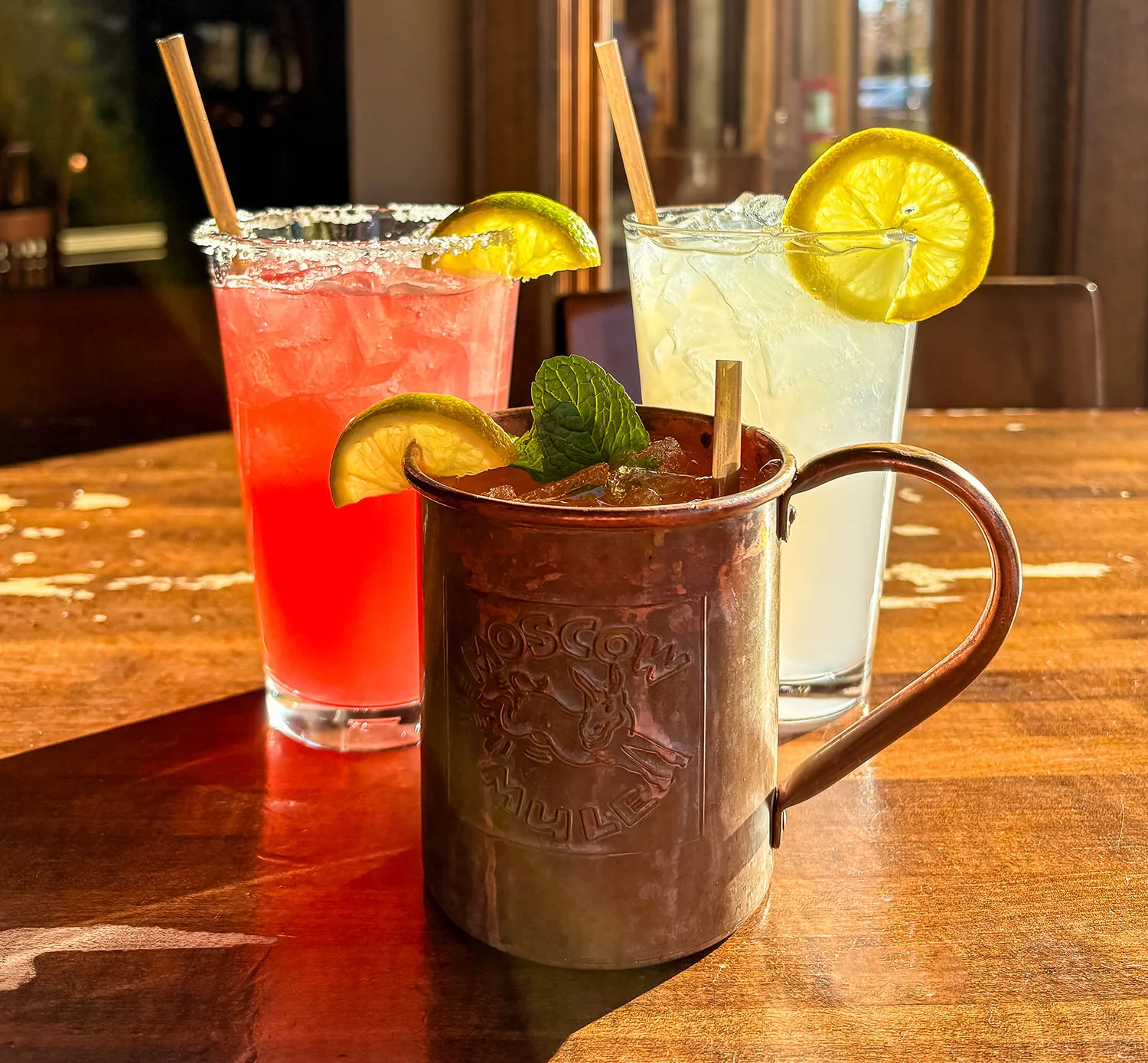 Colorful cocktails on a wooden table in a cozy bar setting