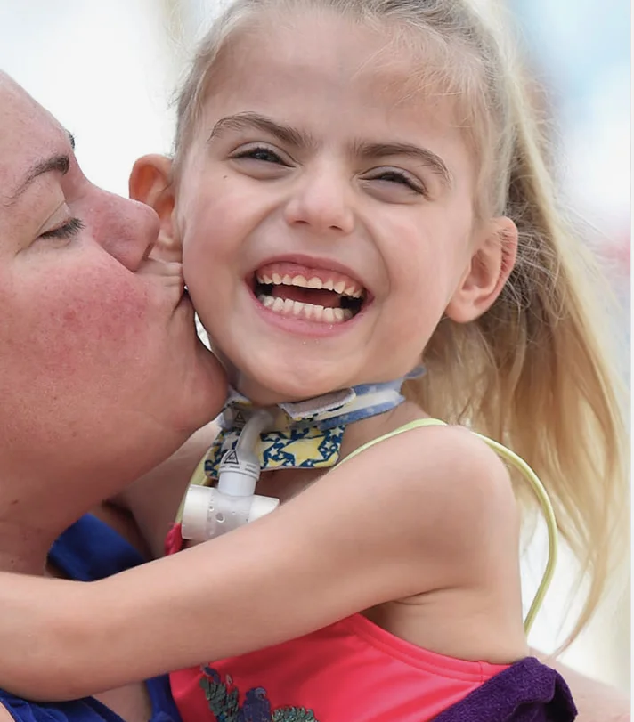 Child laughing joyfully in a playful embrace