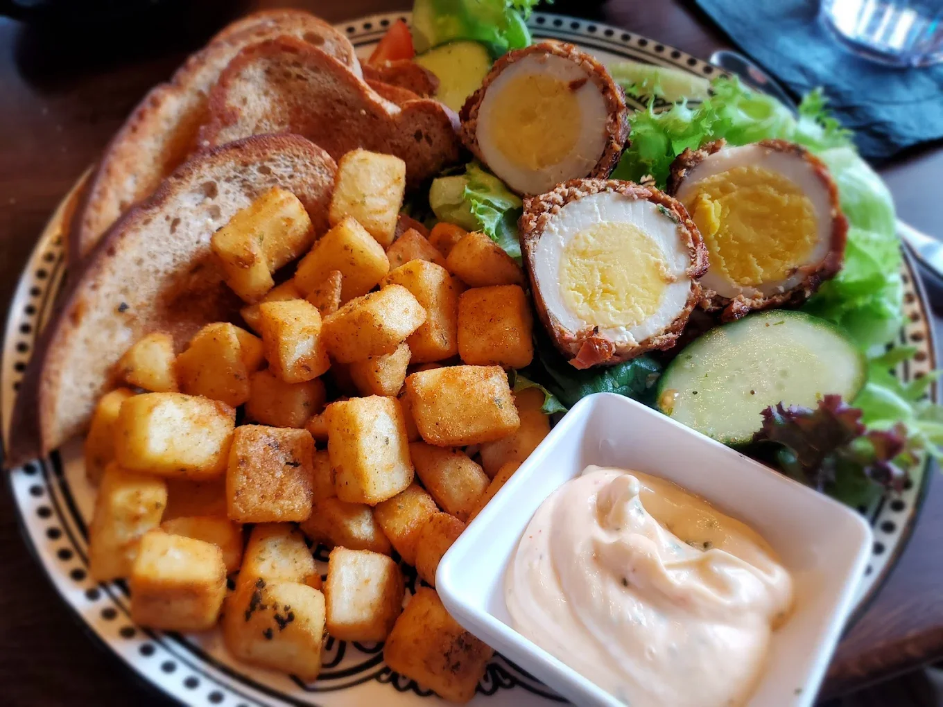 Scottish scotch egg platter with toast and seasoned potatoes