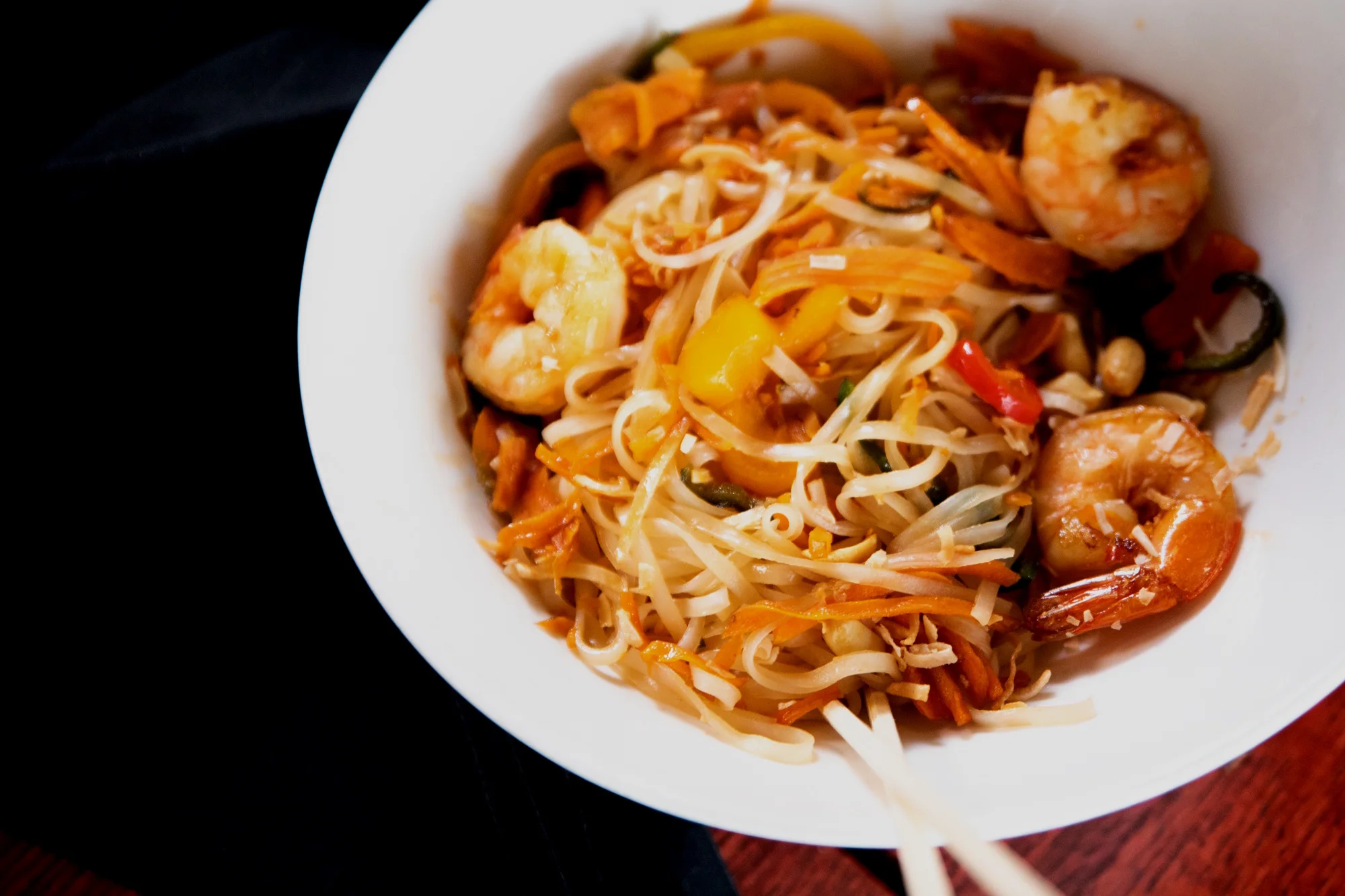 Delicious shrimp pad thai garnished with lime and peanuts.