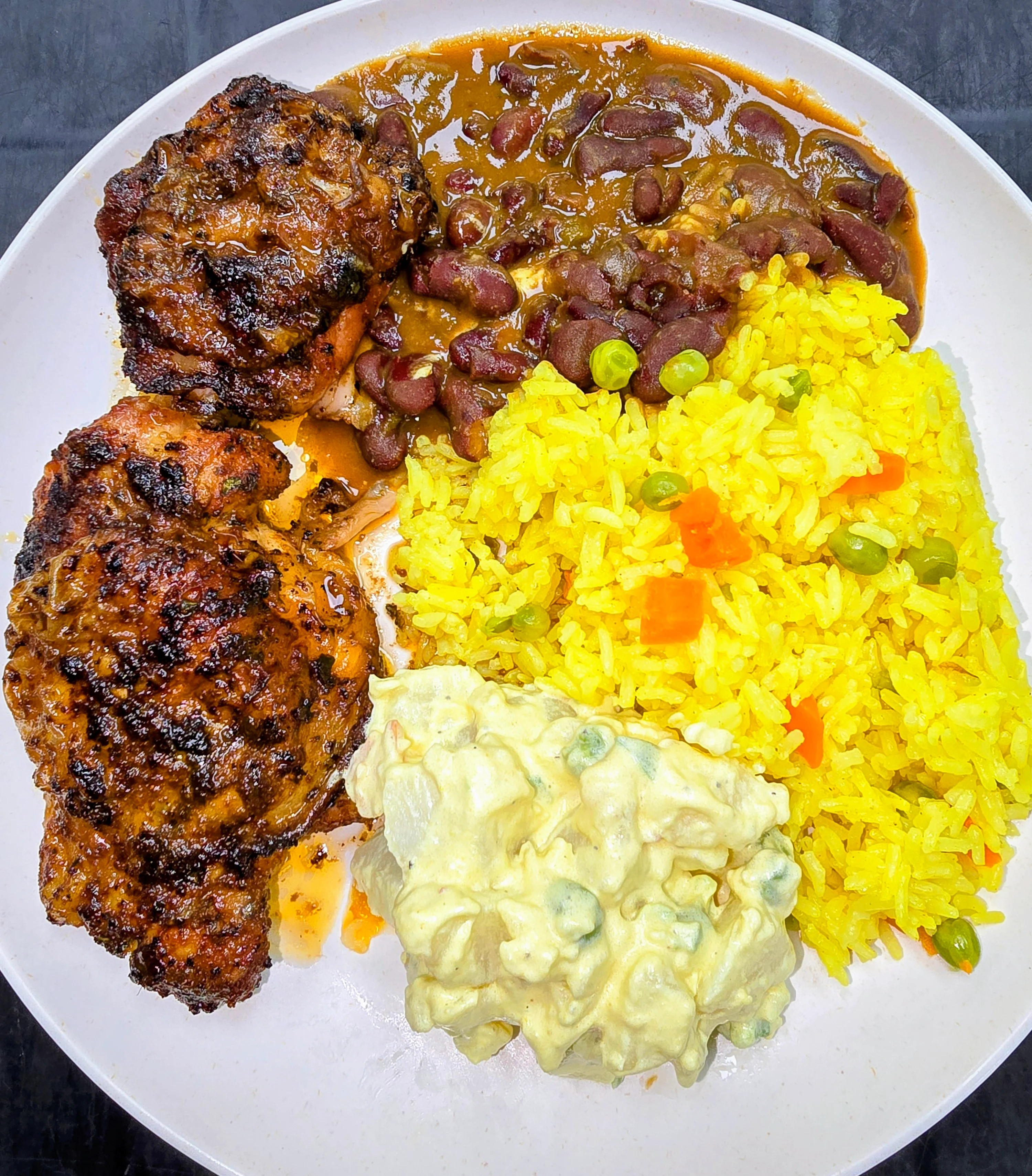 Delicious baked chicken meal served with sides on a plate.