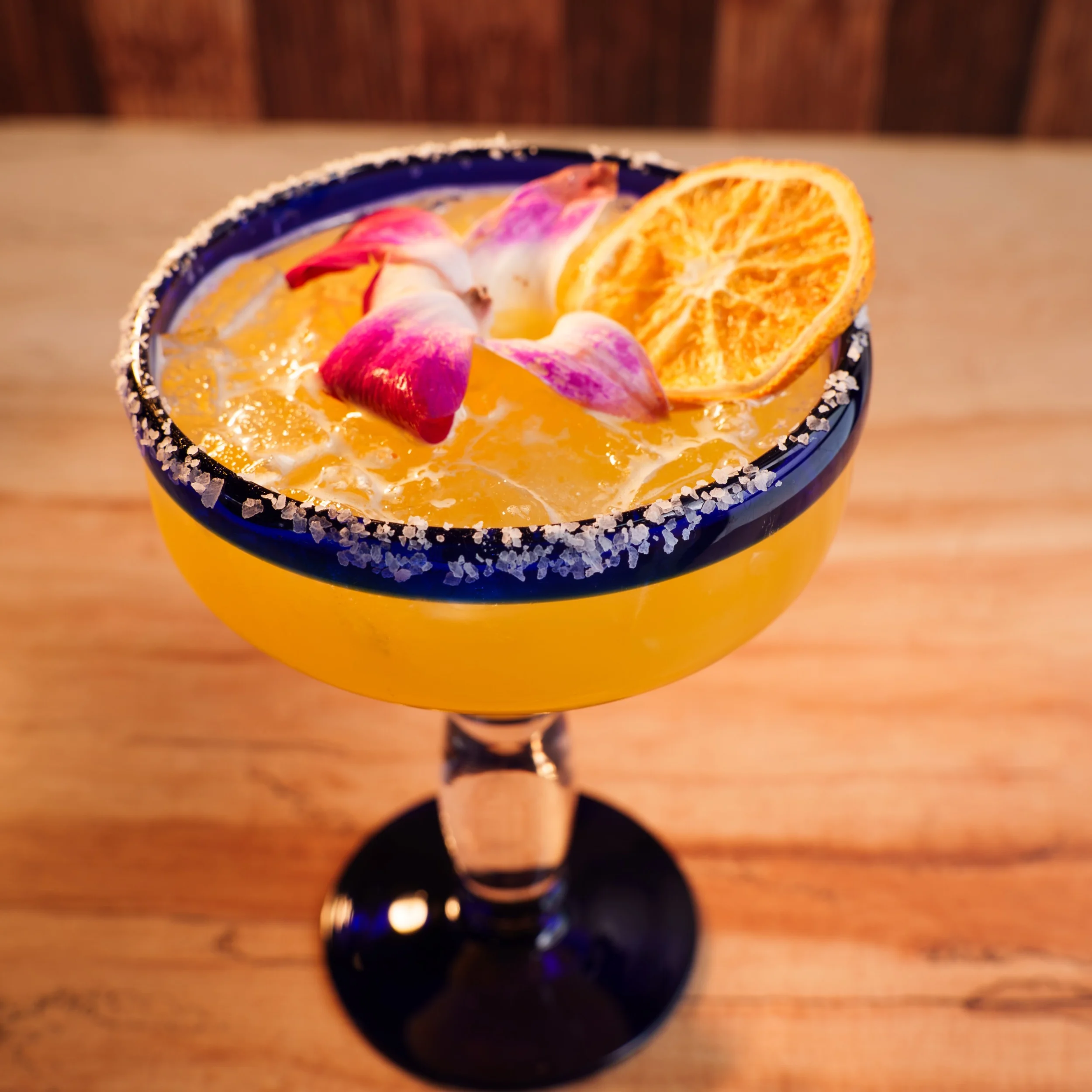 Vibrant margarita cocktail with floral garnish