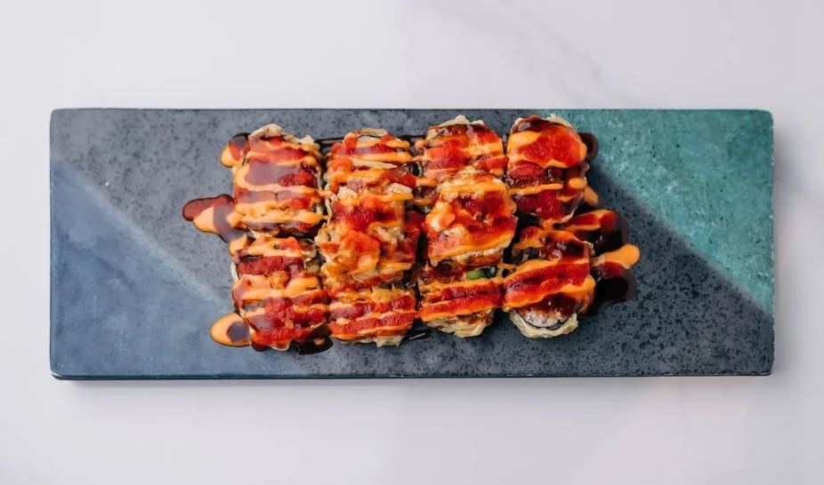 Japanese sushi rolls drizzled with spicy sauce