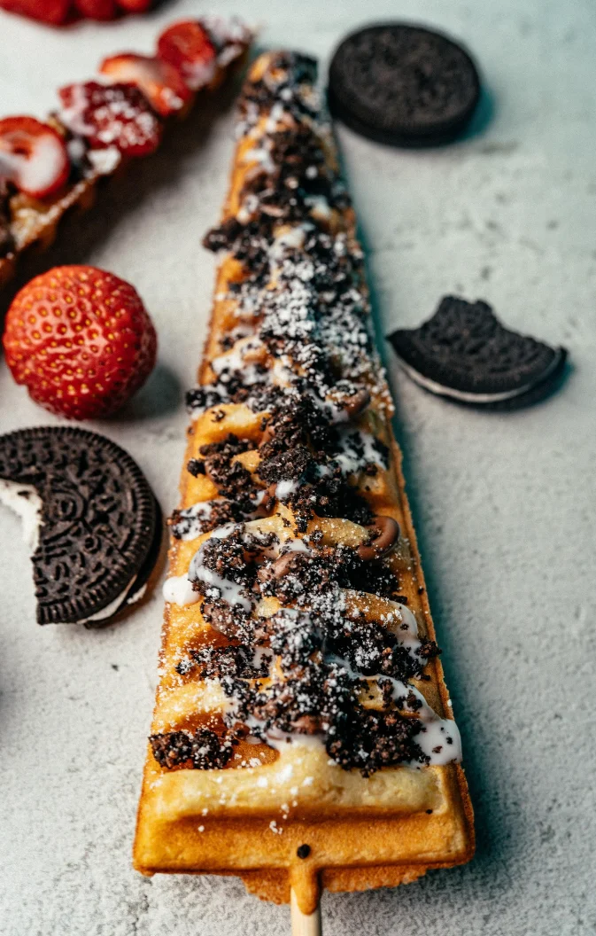Decadent dessert waffle topped with cookies and strawberries