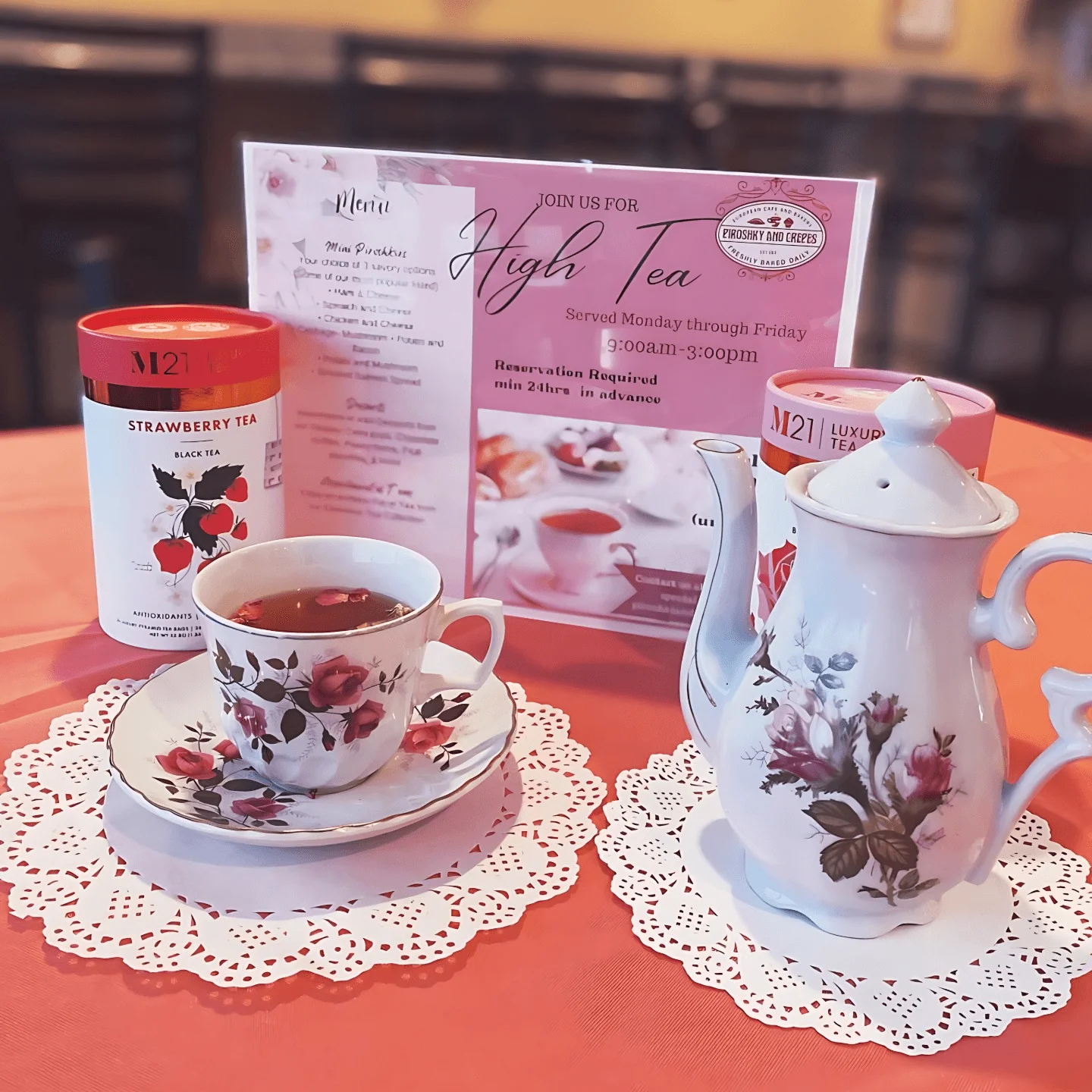 Elegant high tea setup with strawberry tea and floral teapot