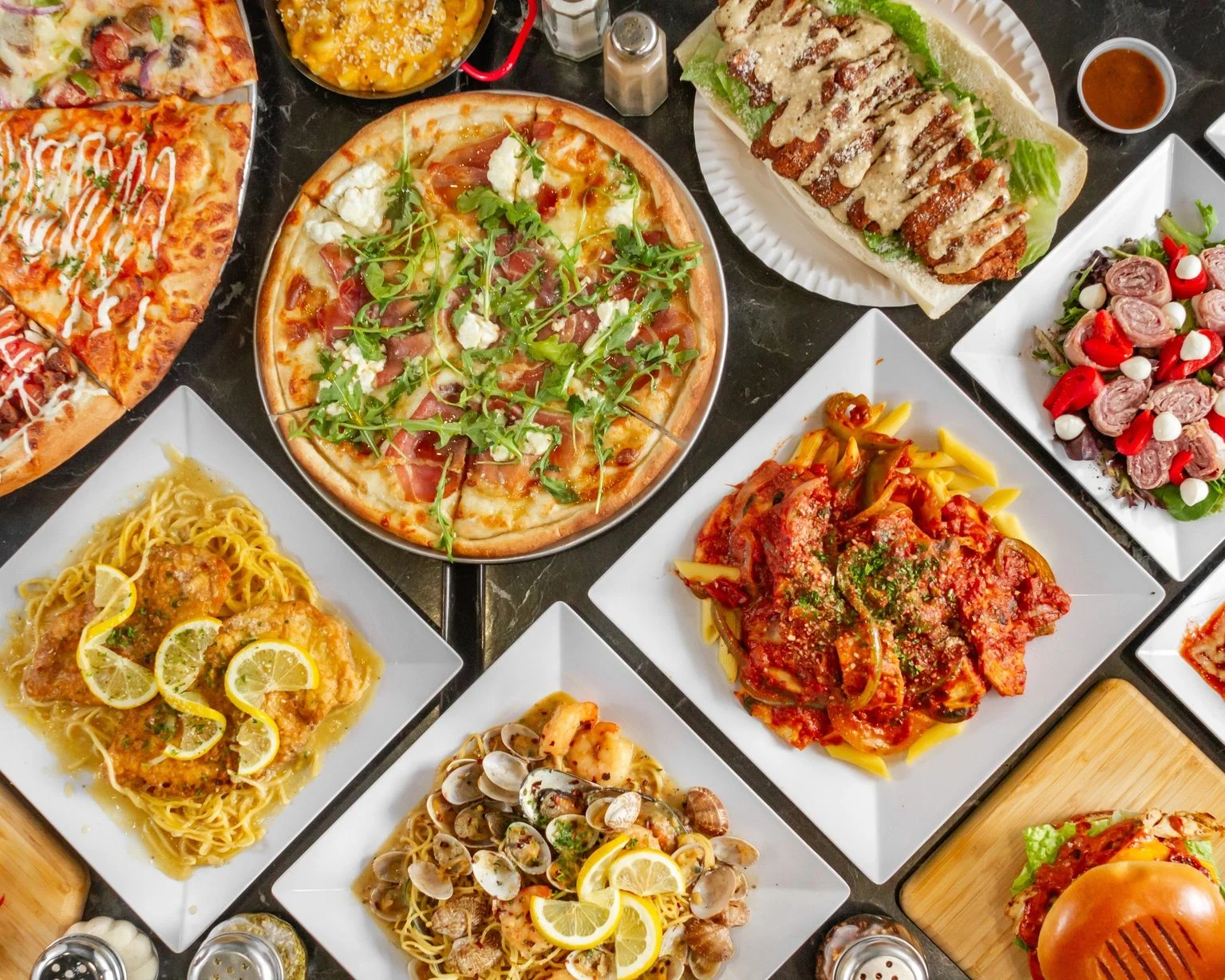 Italian feast featuring pizza, pasta, and seafood dishes