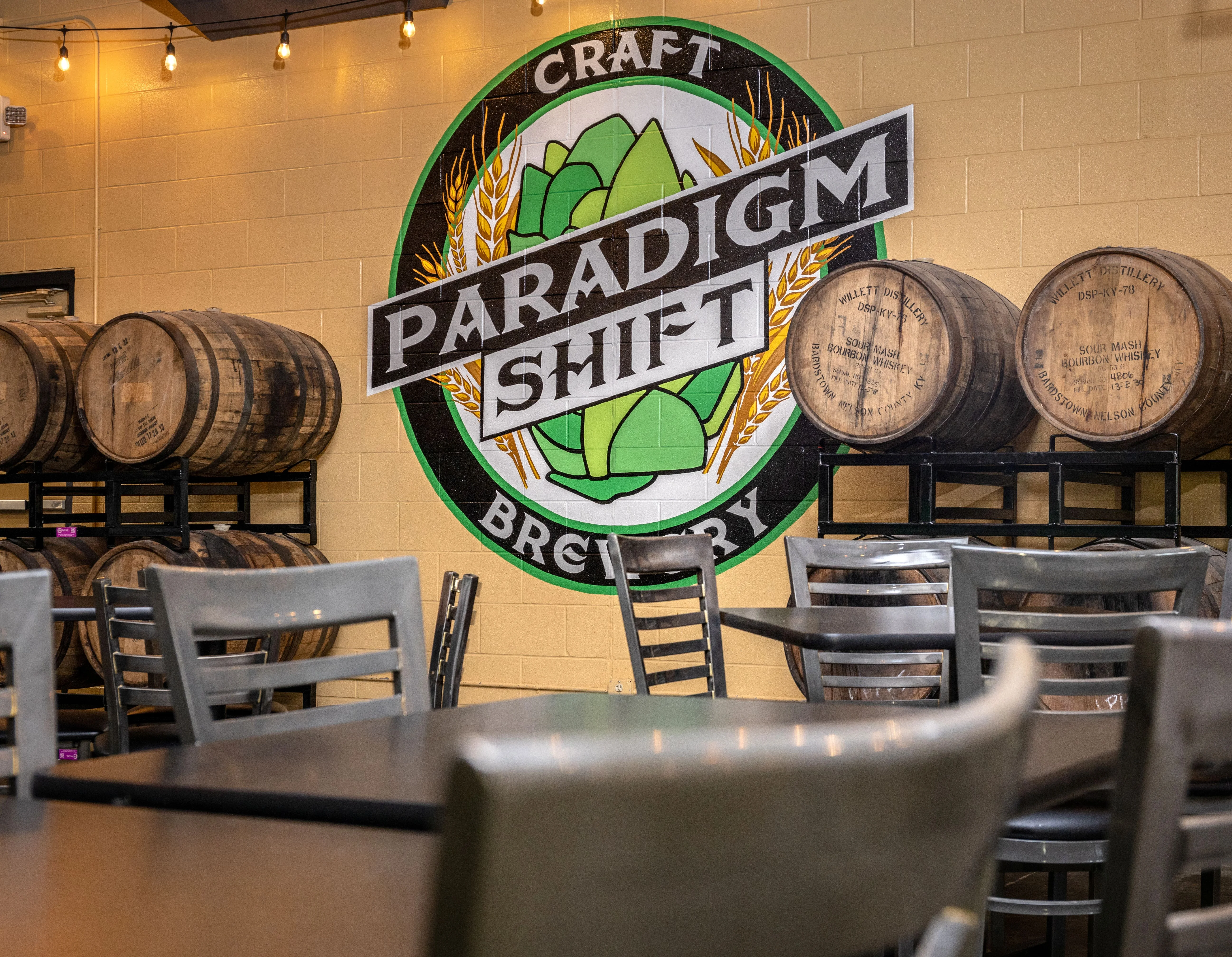 Craft brewery interior with barrels and mural