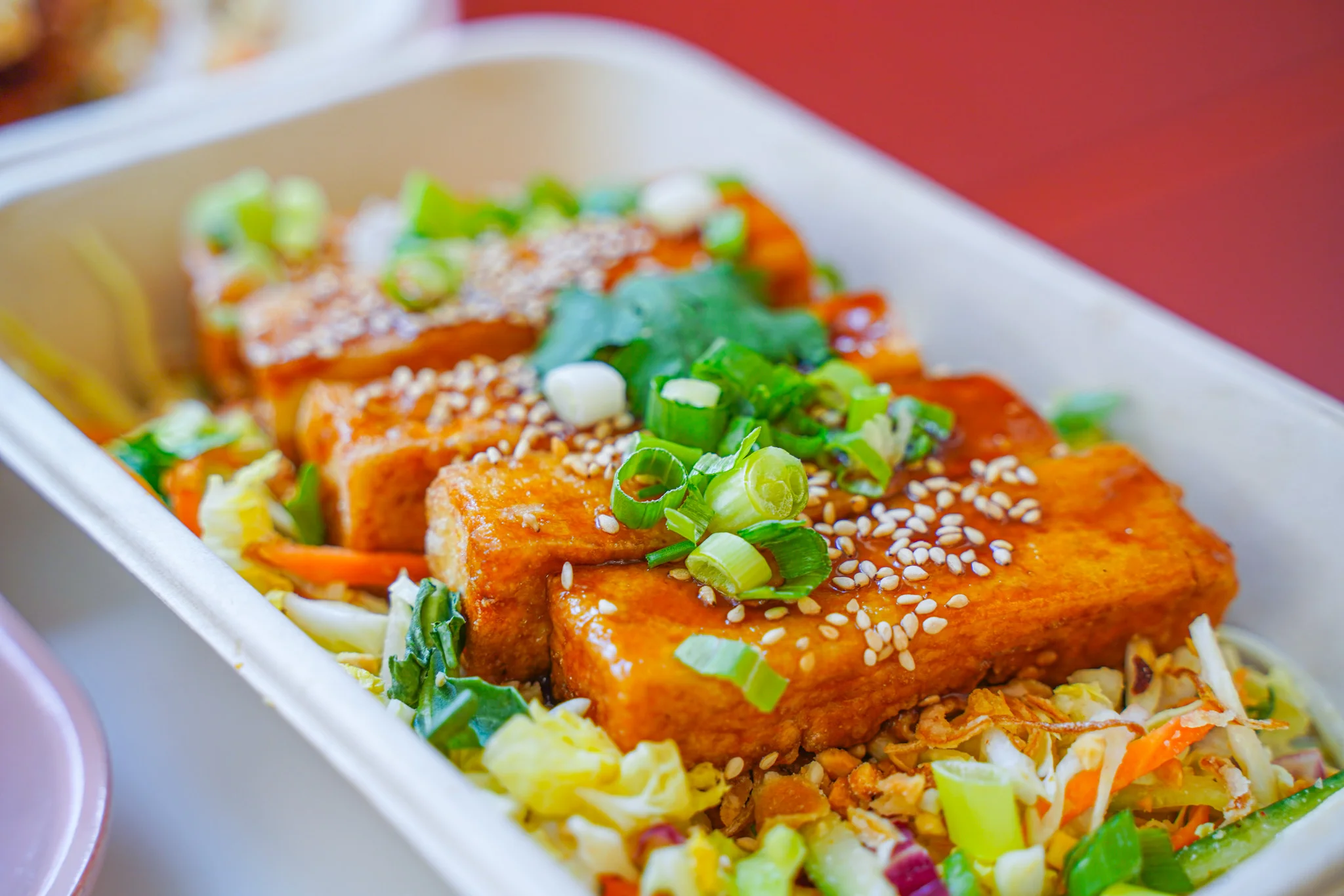 Crispy tofu with sesame and greens in a vibrant Asian-inspired bowl