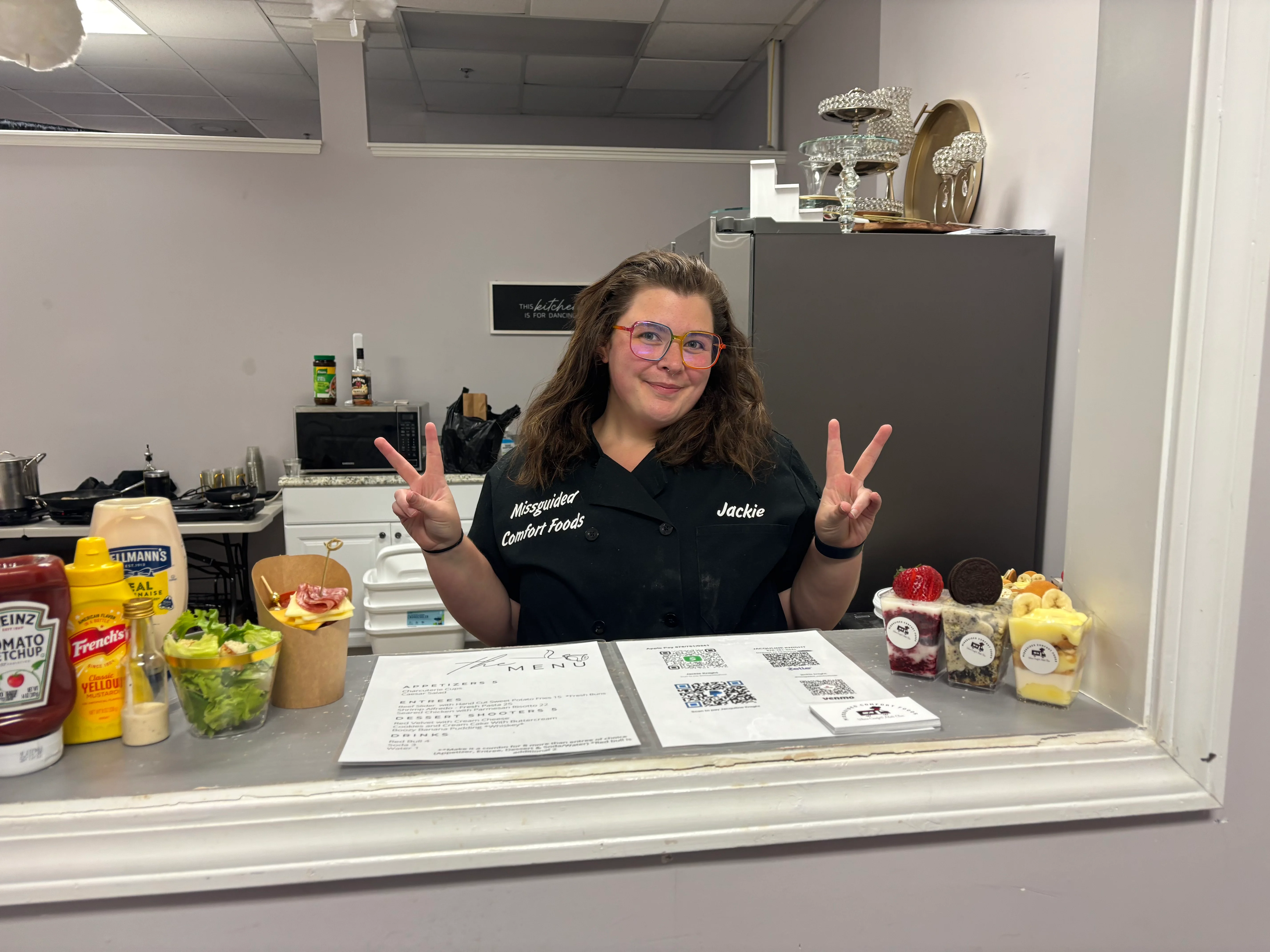 Friendly chef at a comfort food counter with colorful desserts