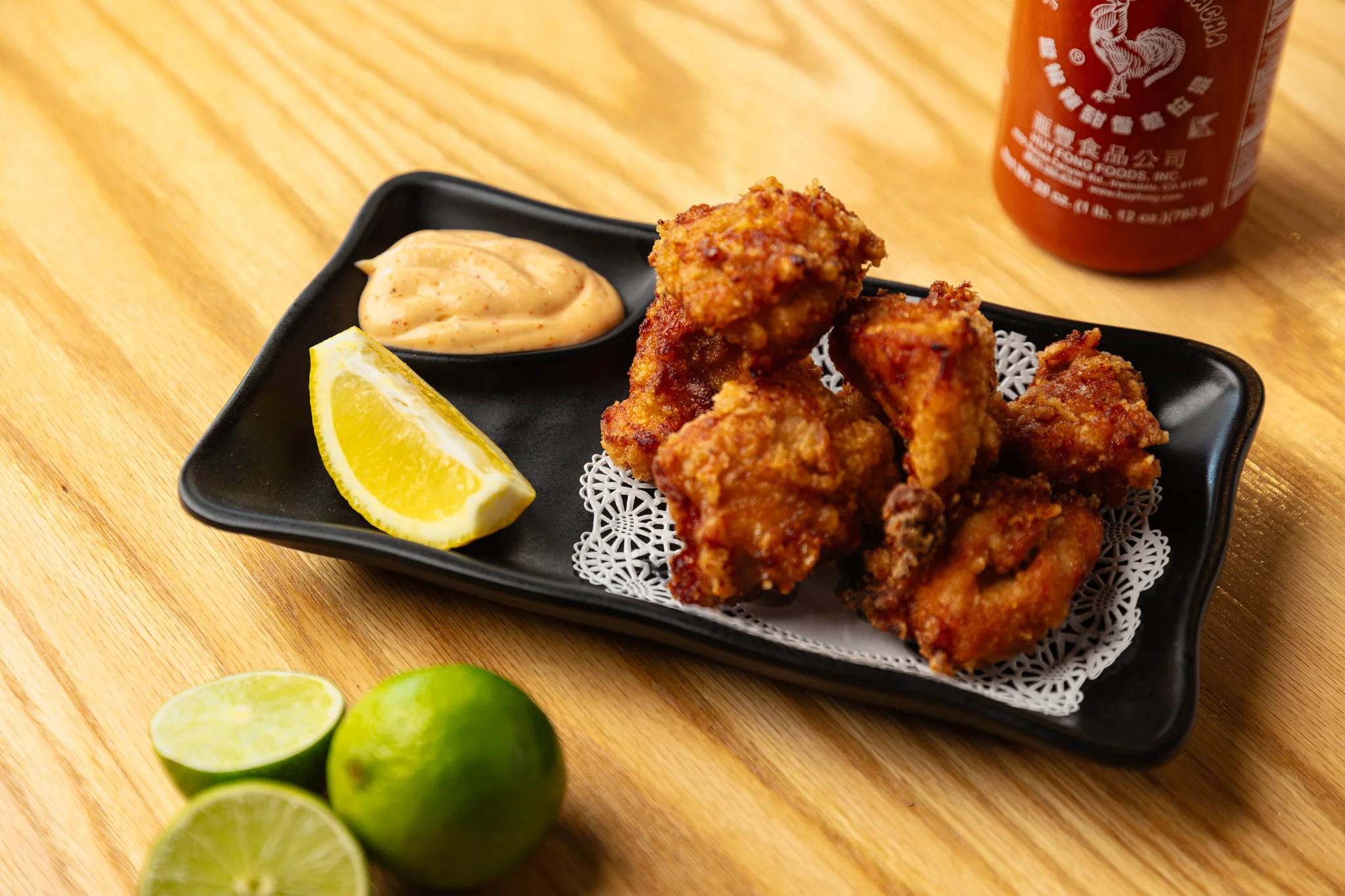 Crispy Korean fried chicken with dipping sauce and citrus