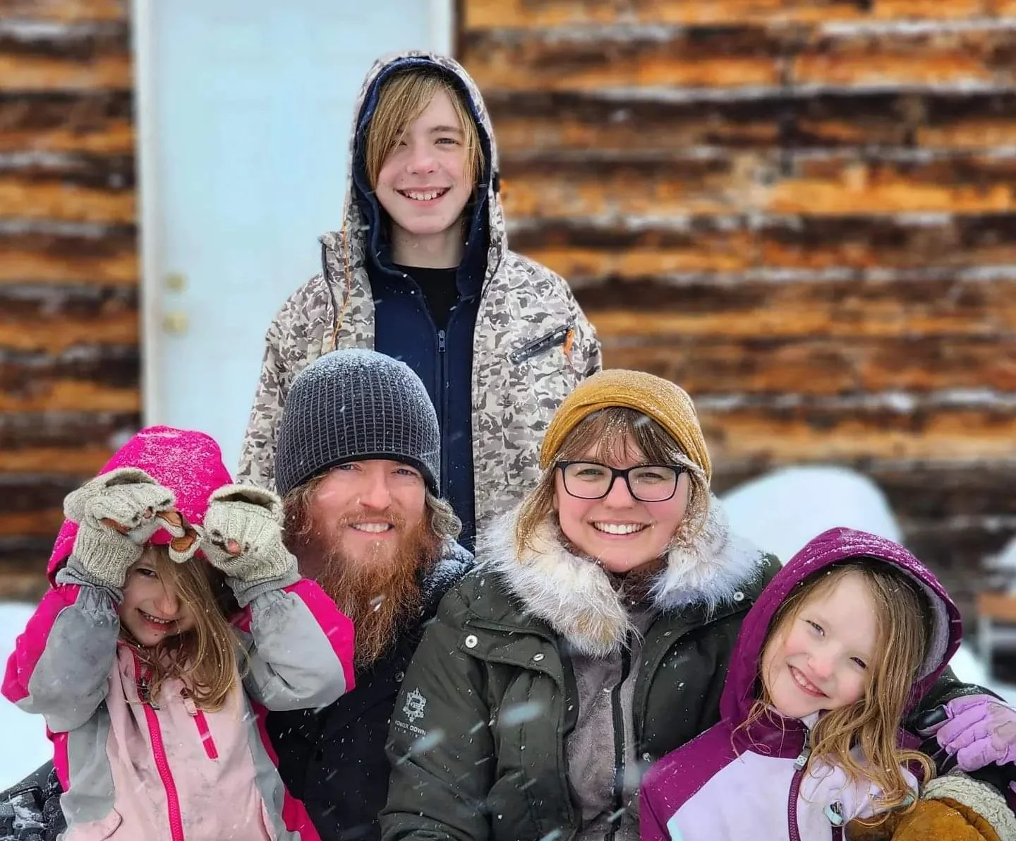Family enjoying a snowy day outdoors in winter attire