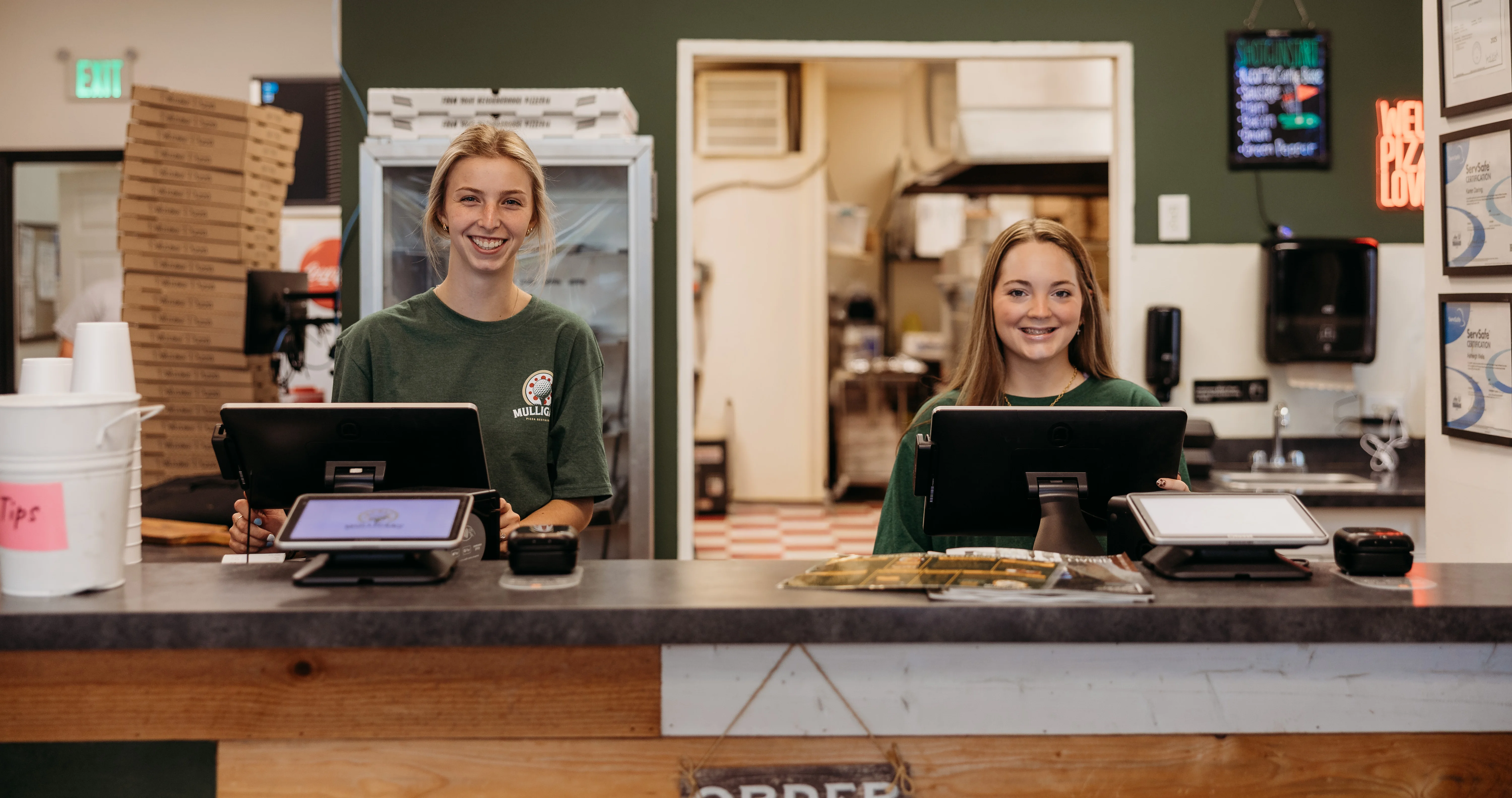 Friendly staff at a pizza restaurant counter
