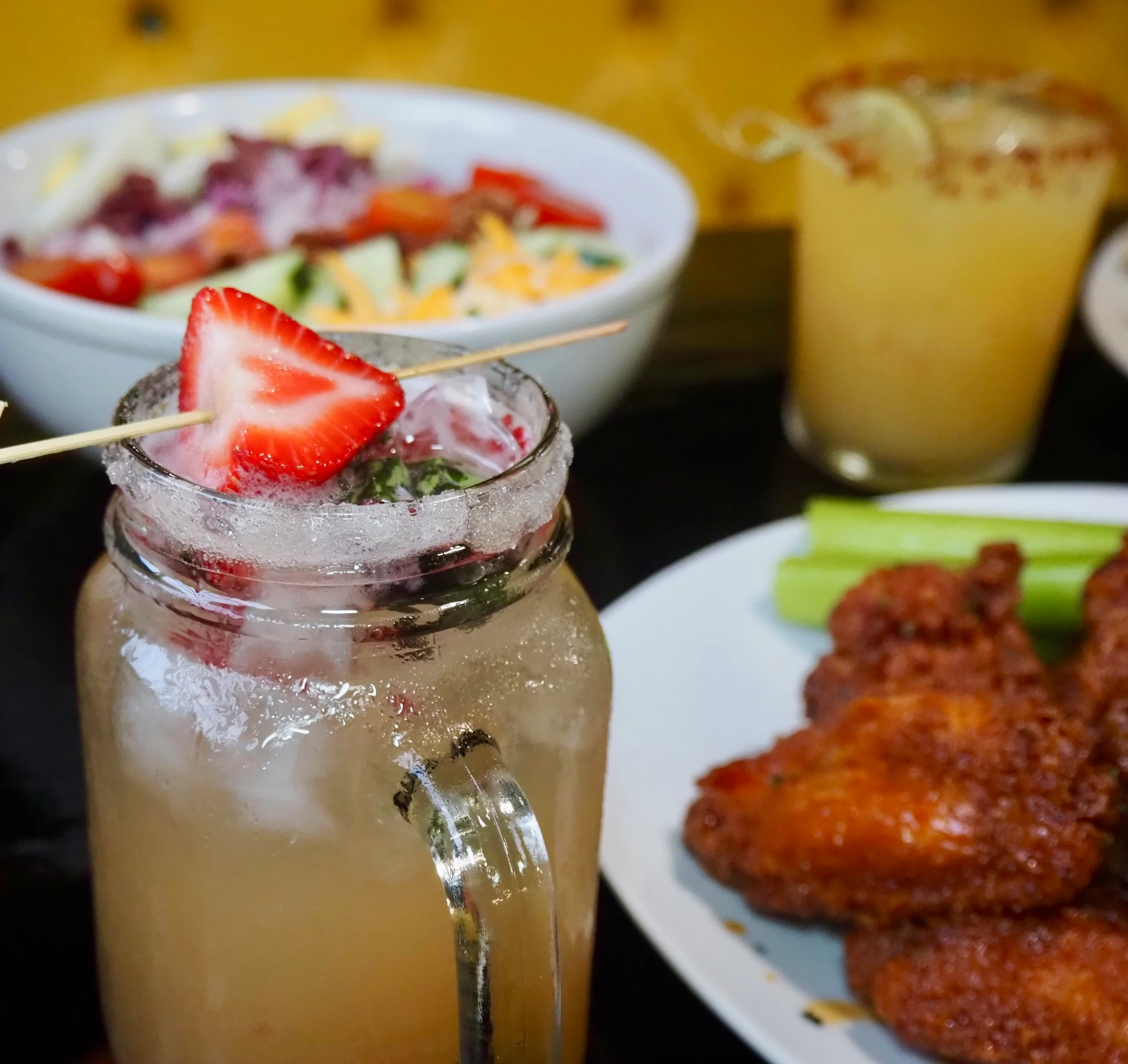 Refreshing cocktail with strawberry garnish in a vibrant bar setting