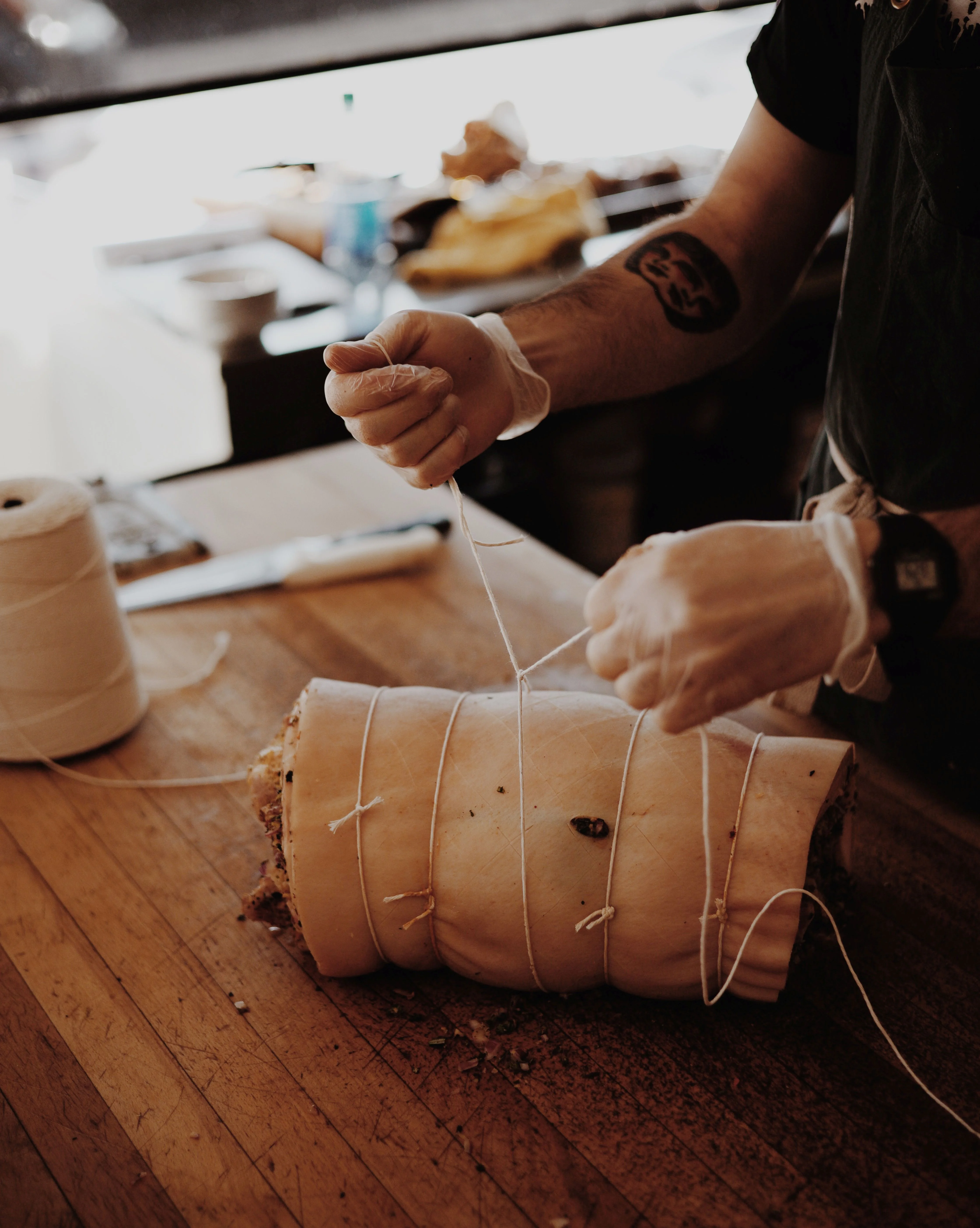 Chef tying a pork roast for cooking preparation