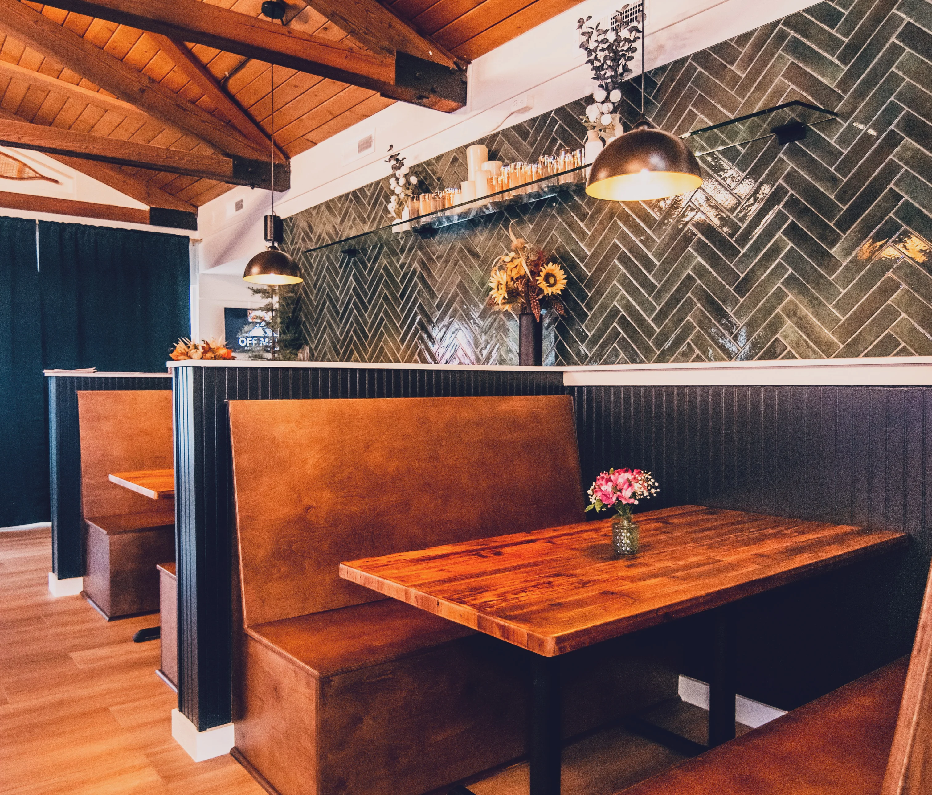 An inviting interior of a restaurant featuring cozy booths, wooden accents, and decorative elements.