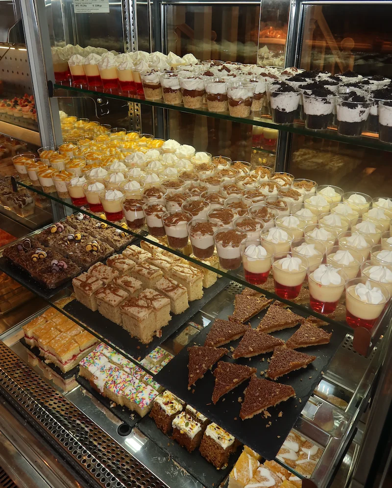 Display of assorted desserts and pastries in a glass case.