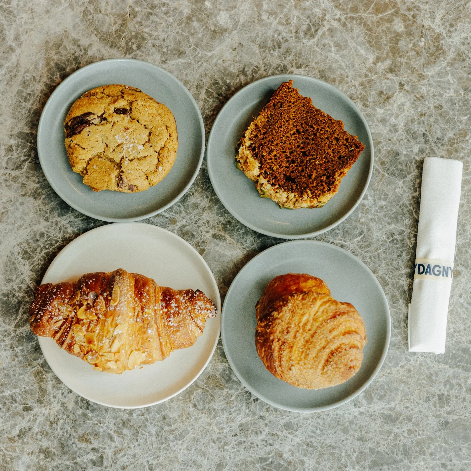 Assorted pastries including croissant and cookie on plates