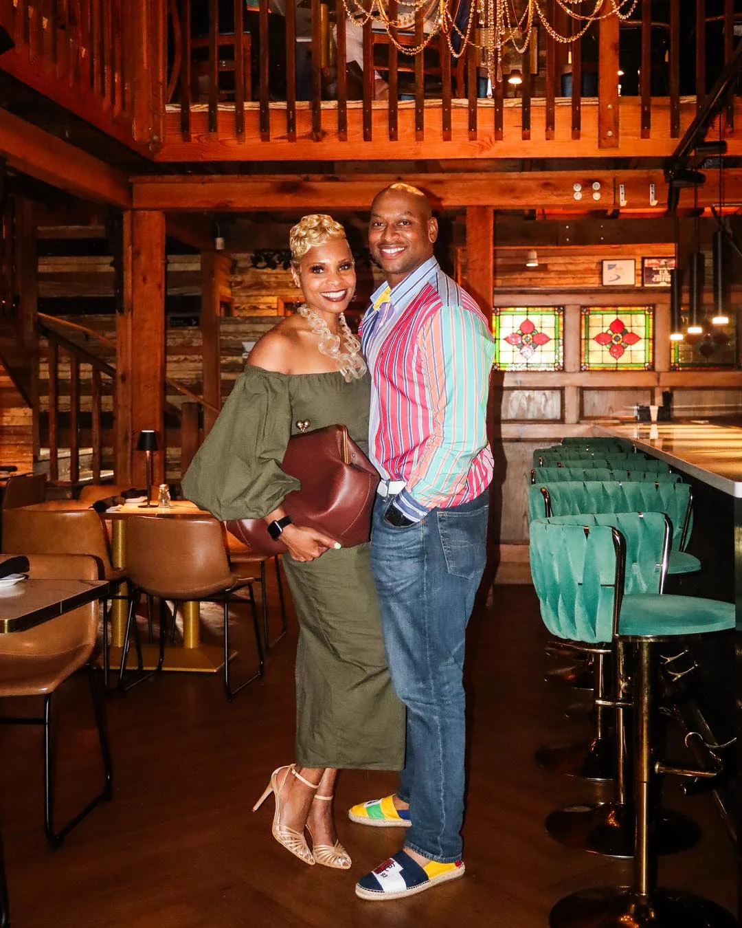 Couple posing in a stylish restaurant interior with wooden decor