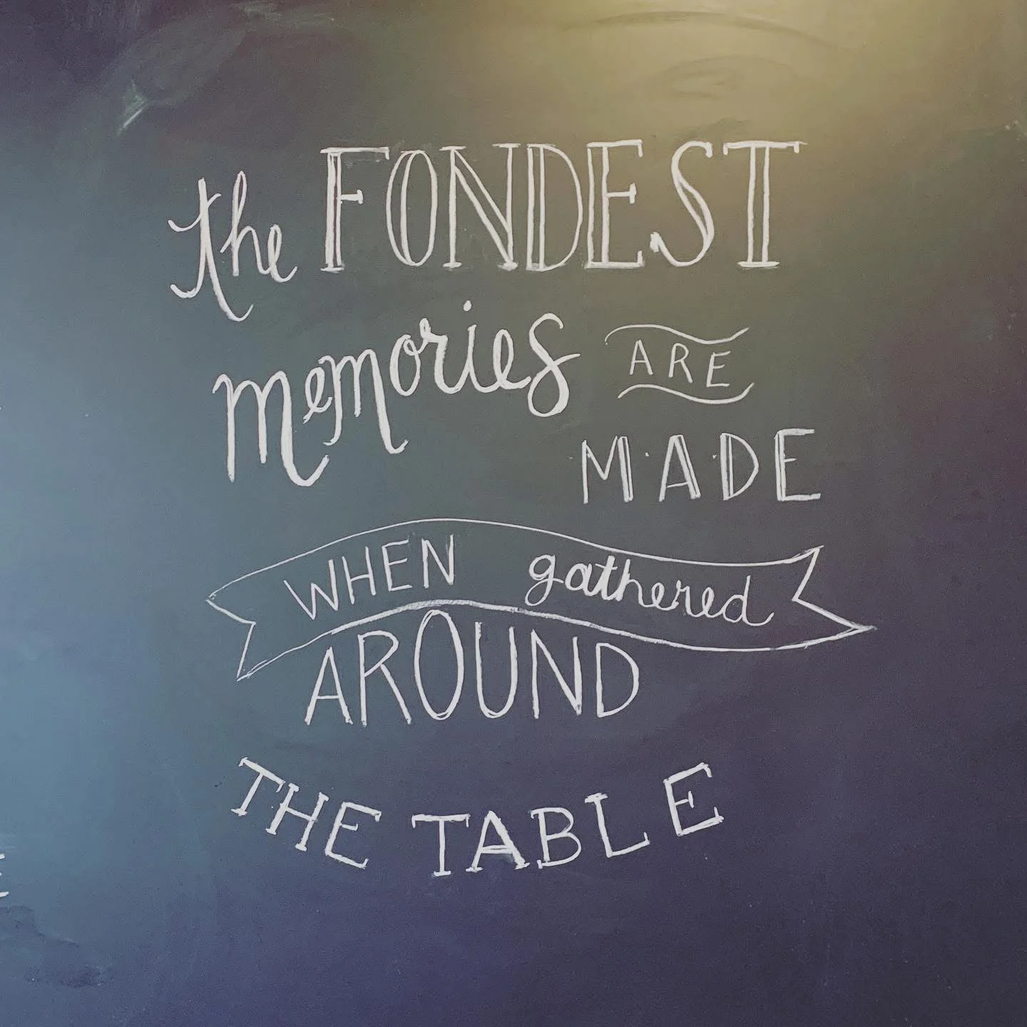 Inspirational quote on a chalkboard about memories made around the table