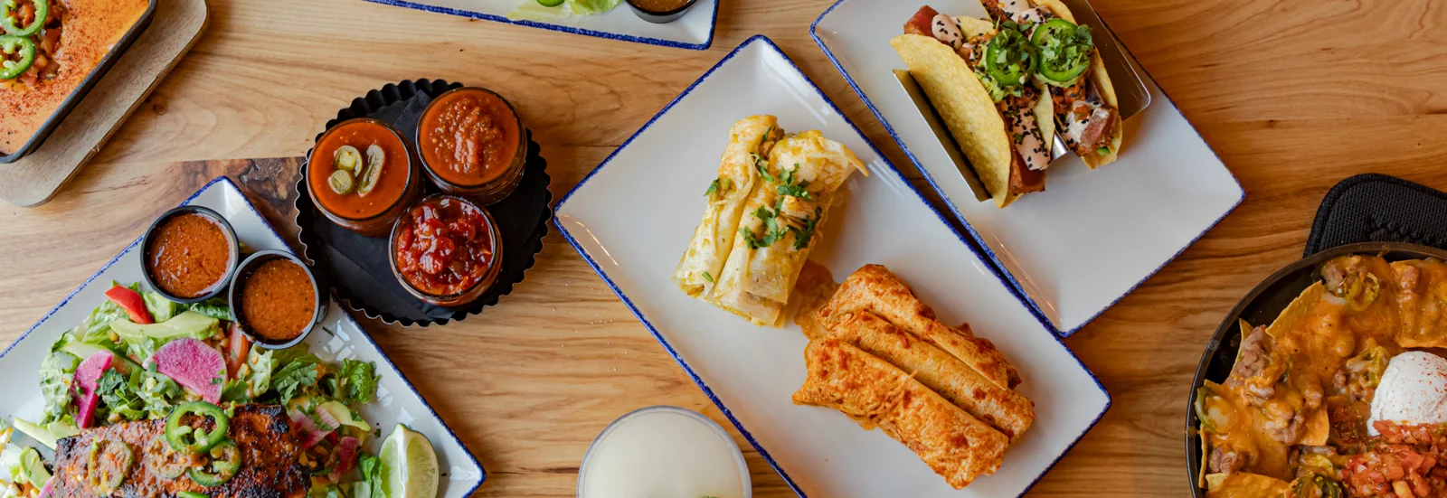 Colorful Mexican feast with tacos, enchiladas, and shrimp salad