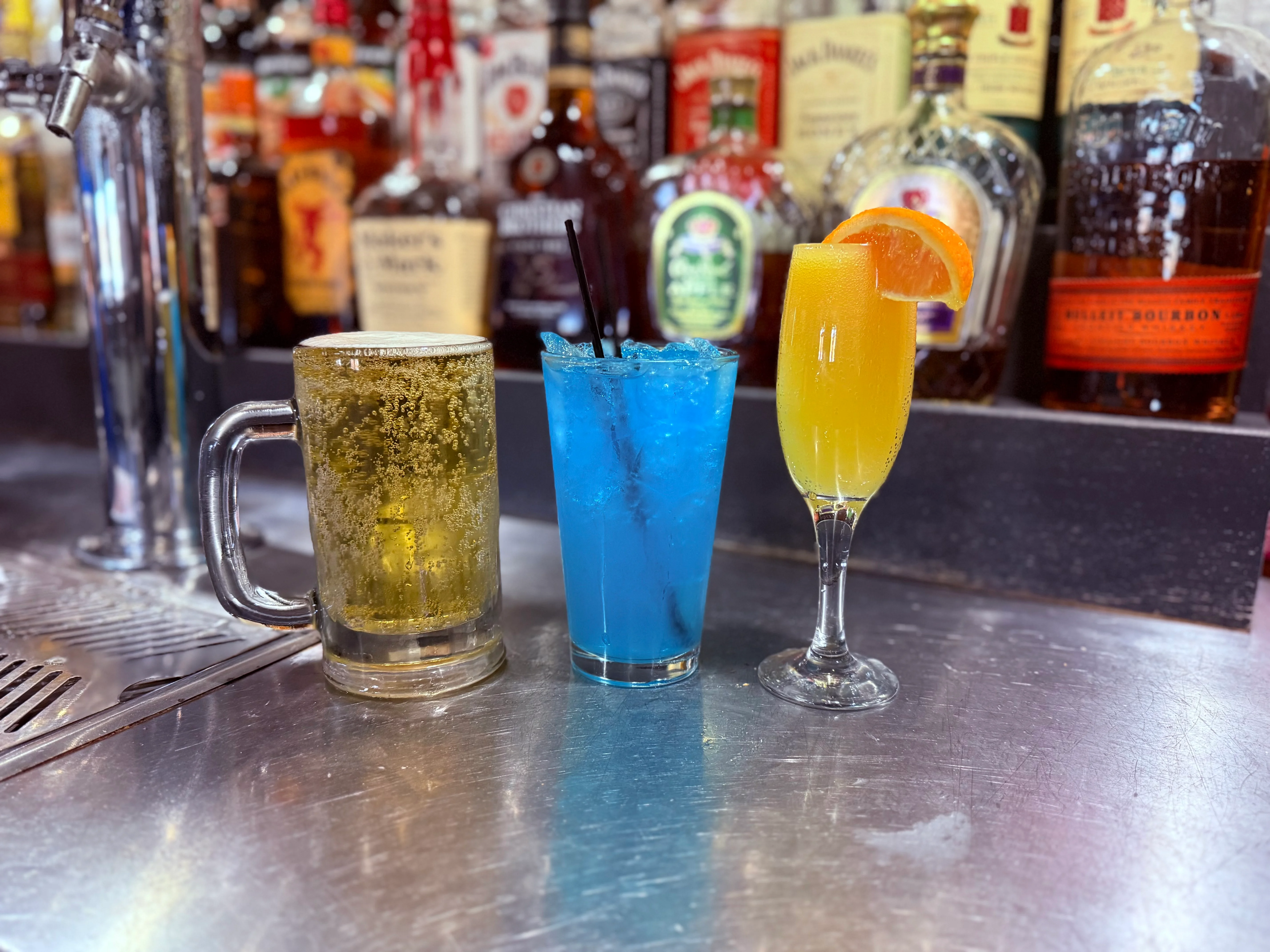 Colorful cocktails at a bar with a beer mug